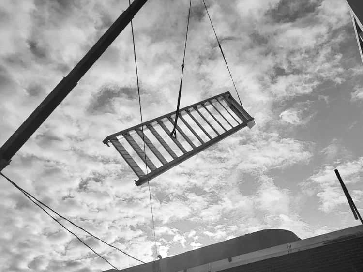 Levage et installation sécurisée d'une structure d'escalier en acier sur un chantier de construction commerciale par l'équipe certifiée RBQ de PAM métal Inc.