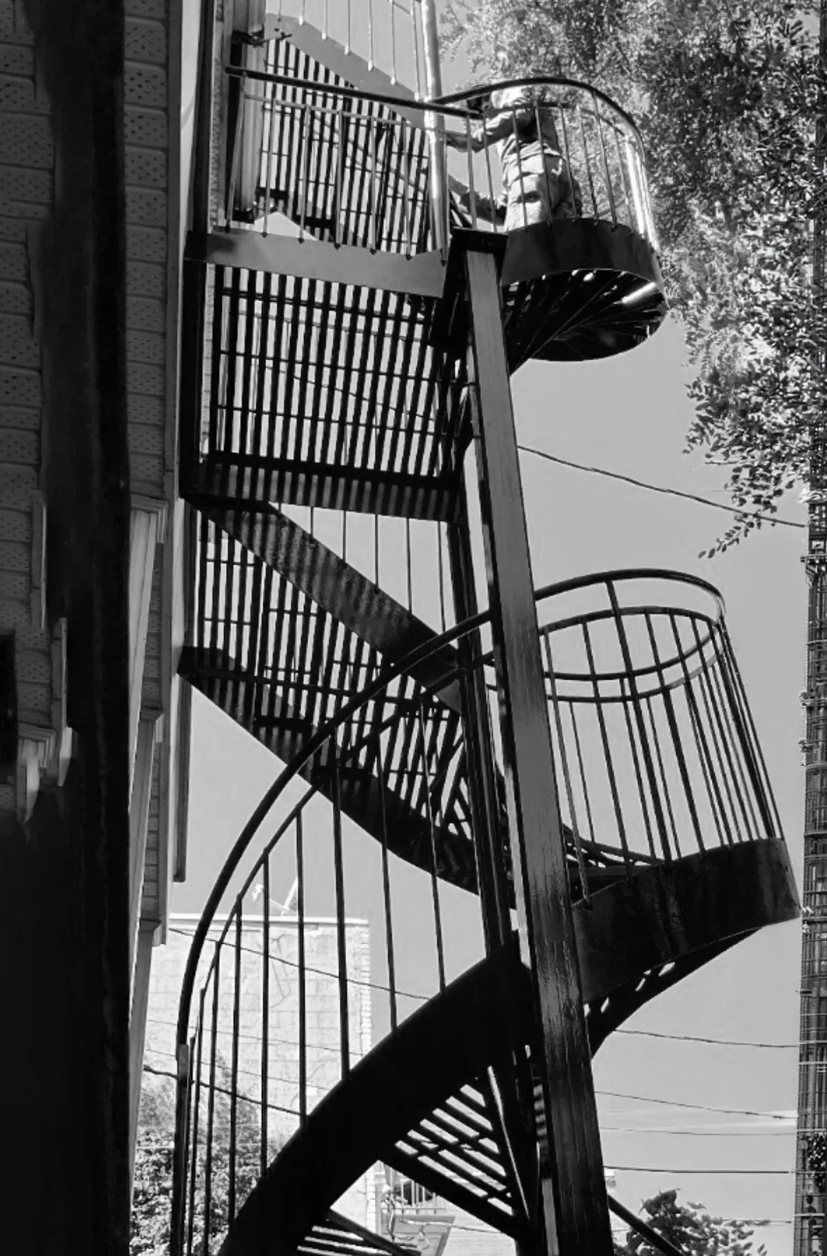 Installation finale d'un escalier de secours en colimaçon noir sur la façade d'une résidence à Montréal par PAM métal Inc.