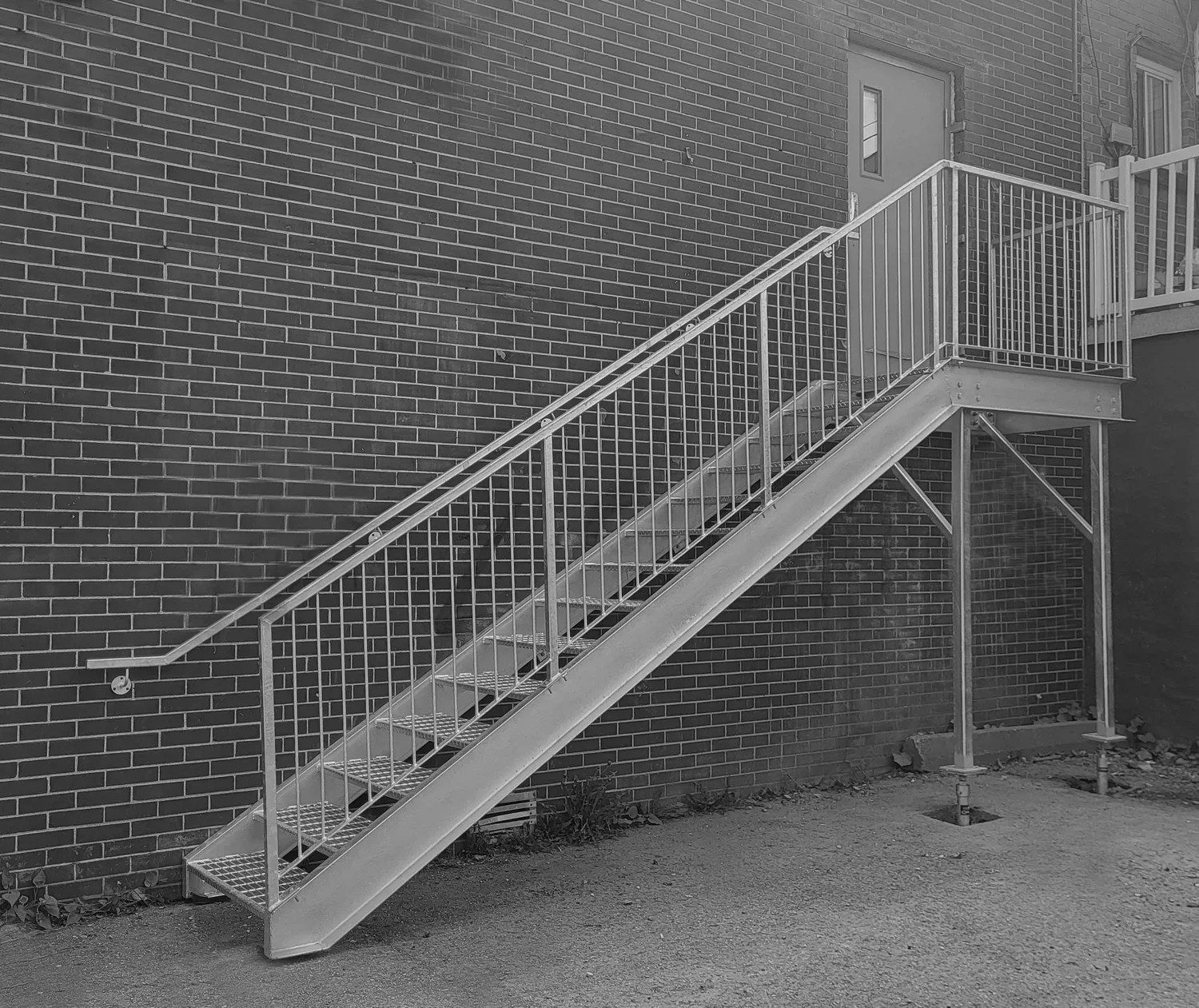 Escalier de sortie d'urgence extérieur en acier galvanisé durable, solidement ancré sur la façade en brique d'une clinique vétérinaire à Hochelaga.