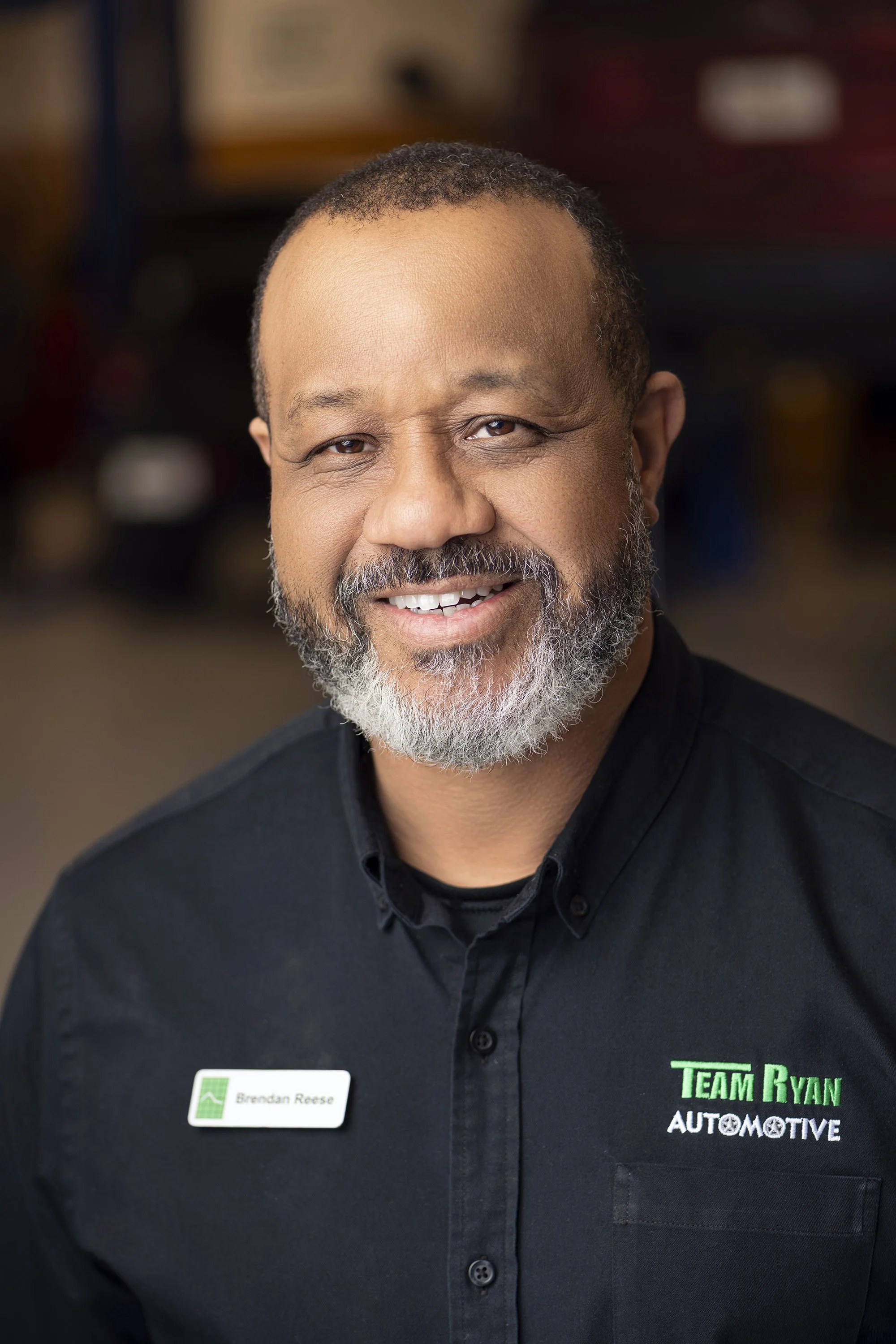 Clean modern corporate headshot of automotive technician photographed inside Team Ryan Automotive shop in Buford, Georgia by Atlanta portrait photographer Caitlin Tabilog.