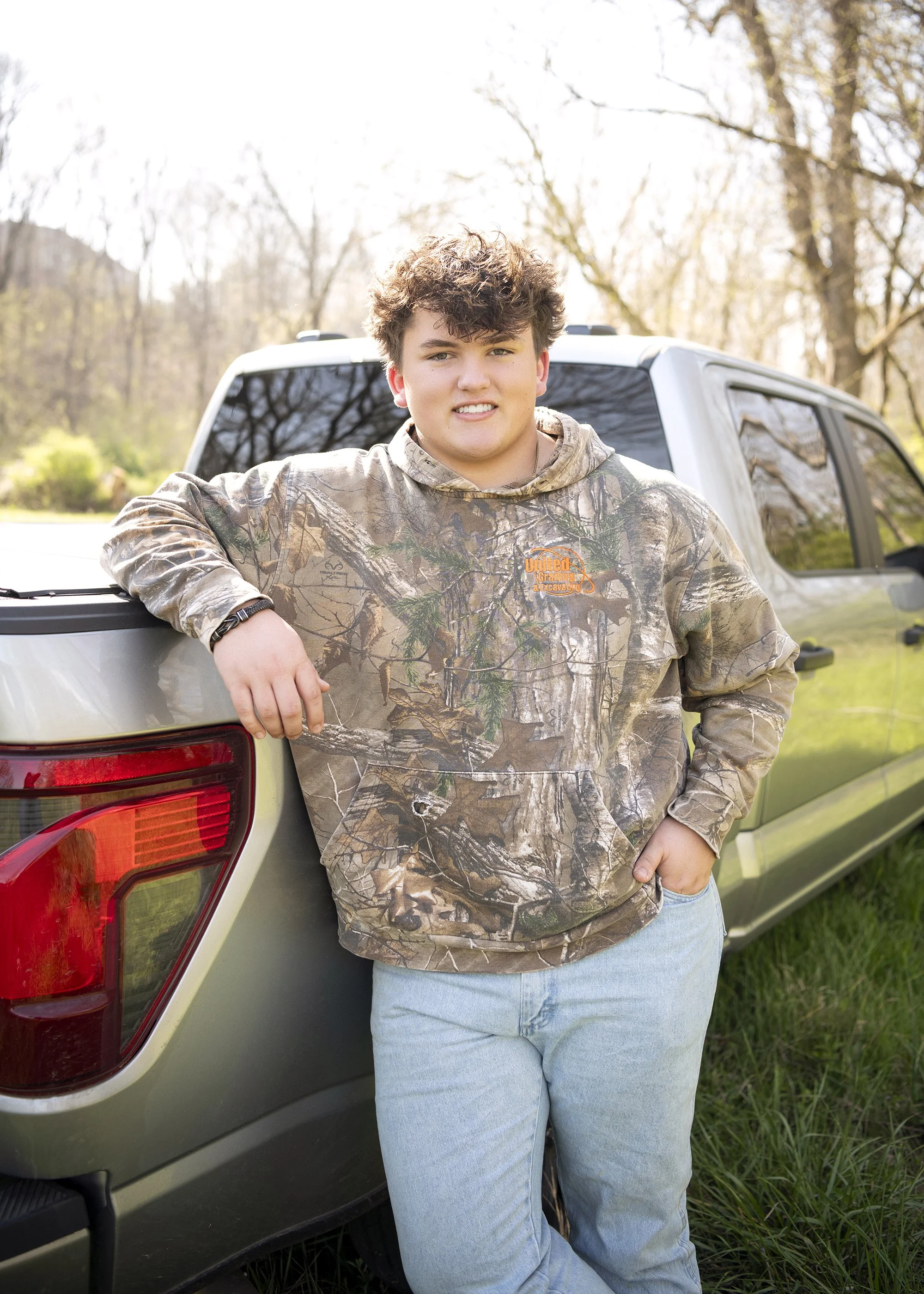 Jacob Sluss senior portrait photography session on a farm in Woodstock Georgia with relaxed poses, natural light, and candid expressions by Atlanta senior photographer.