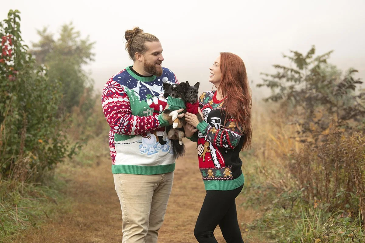 Outdoor family portraits of Brian Larson, his girlfriend, and their two dogs at Garrard Landing Park in Marietta, Georgia, captured in natural light for holiday cards in Christmas sweaters by Caitlin Tabilog of Atlanta Portrait Co, top Atlanta family