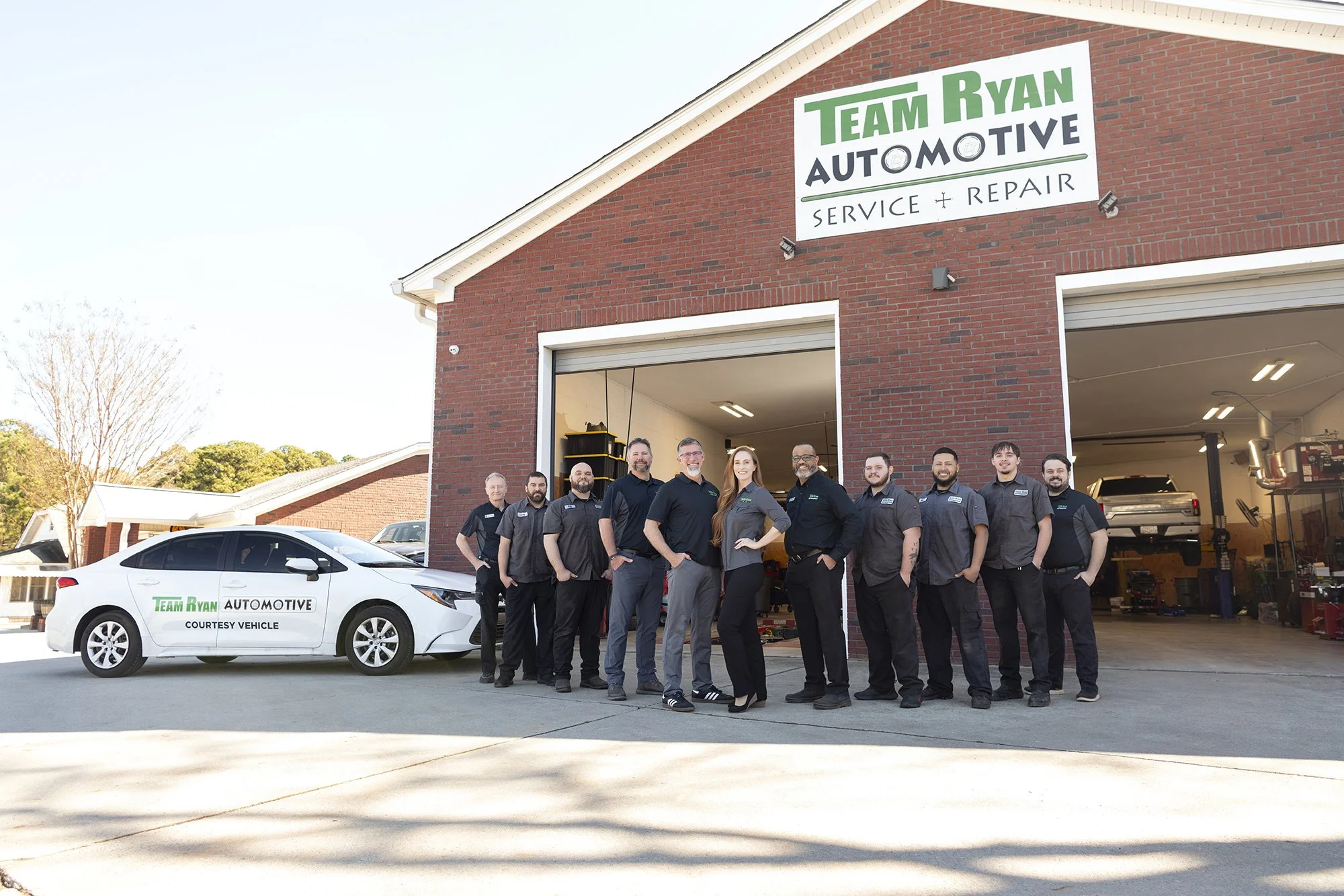 Corporate team branding photoshoot at Team Ryan Automotive in Buford Georgia, featuring all staff members with professional on-site studio lighting.