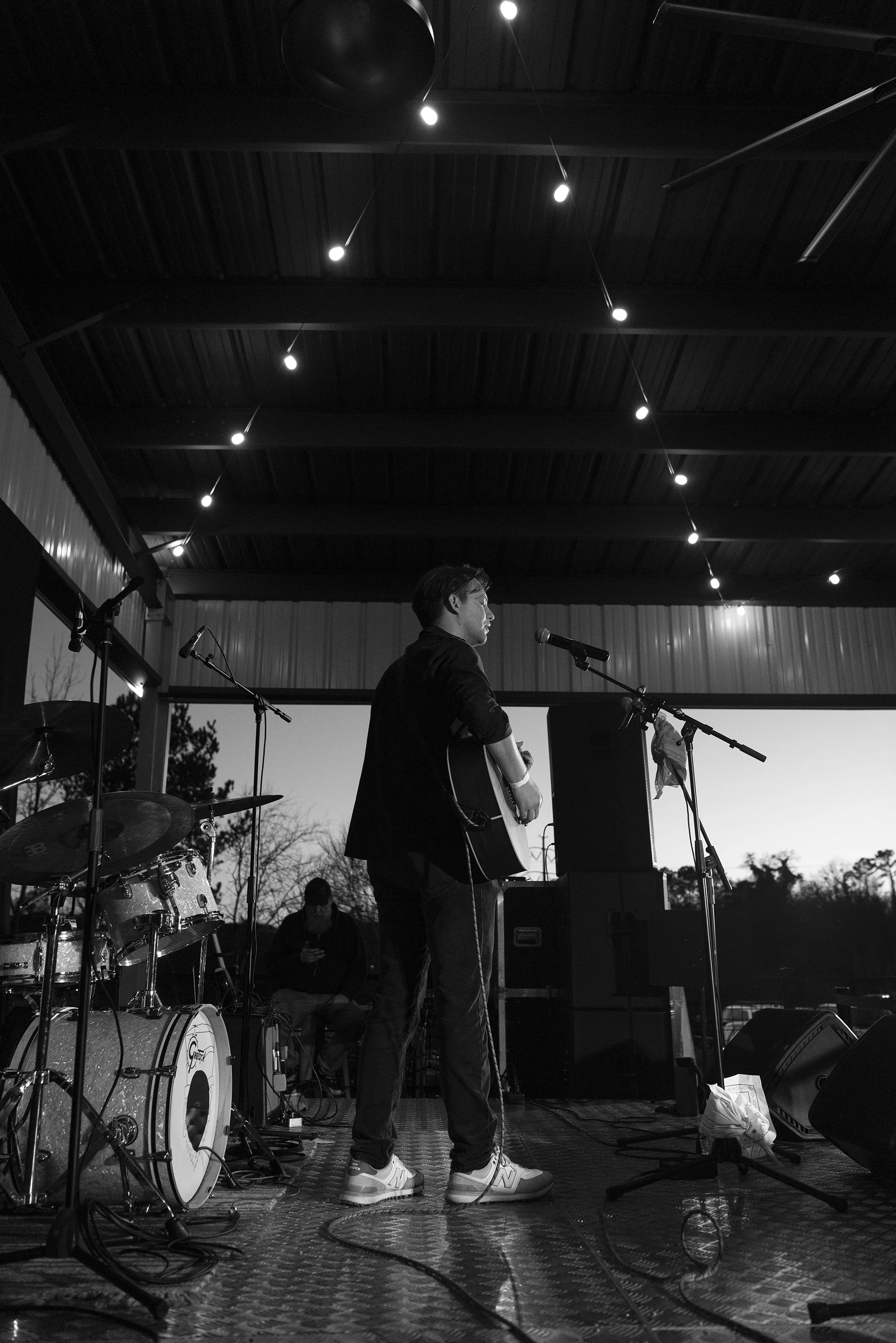 Professional Atlanta concert photographer Caitlin Tabilog documenting live music event at Reformation Brewery Canton Georgia, candid band moments with guitarist drummer and vocalist performing on stage