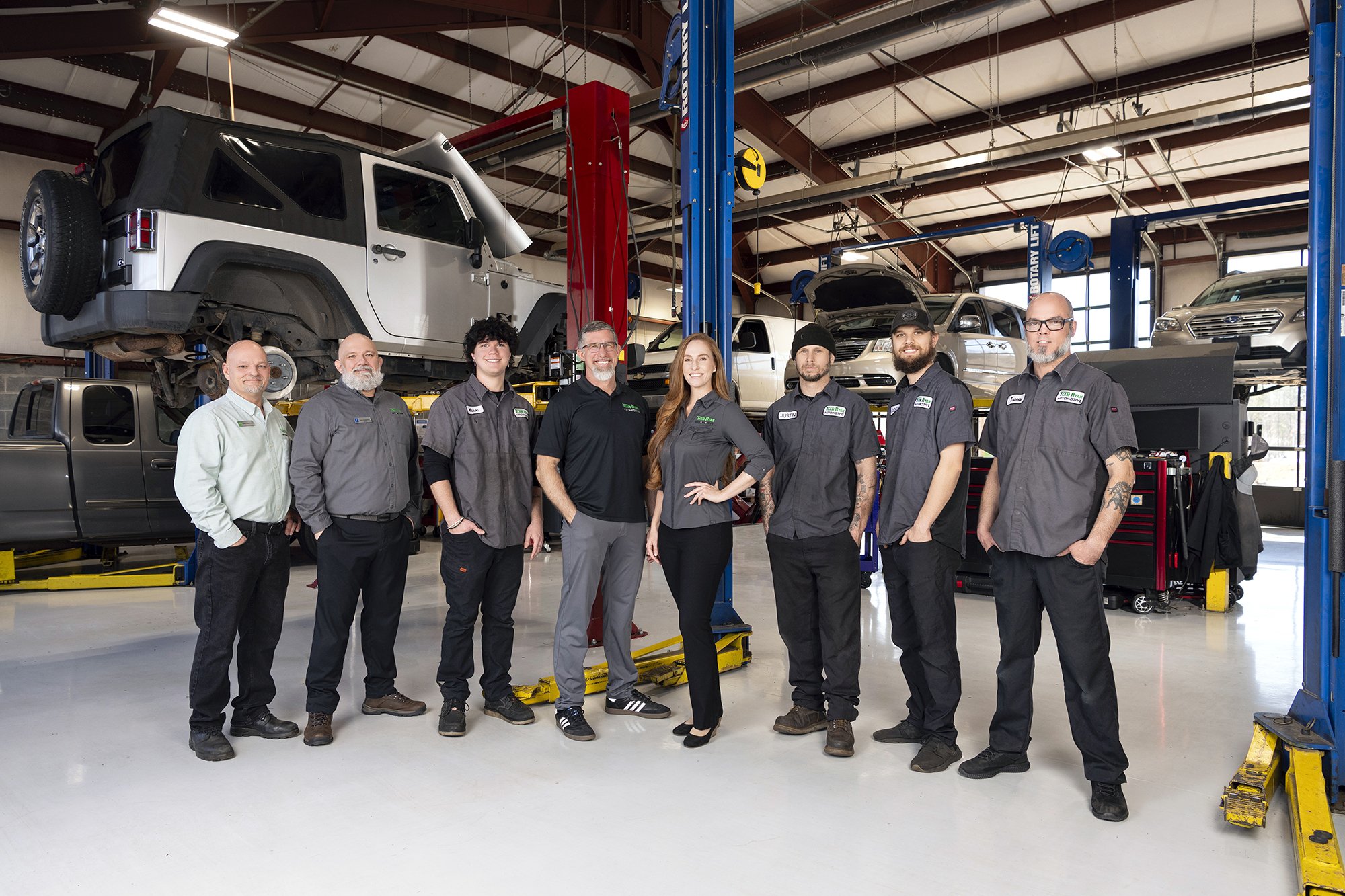 Team Ryan Automotive staff group headshots photographed on location inside their mechanic shop with studio lighting by Atlanta portrait photographer Caitlin Tabilog.