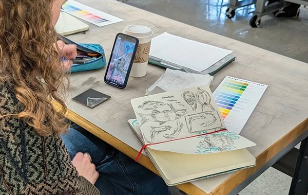 Zoe Gilmore sketching scientific specimens and researching/learning while making art from it
