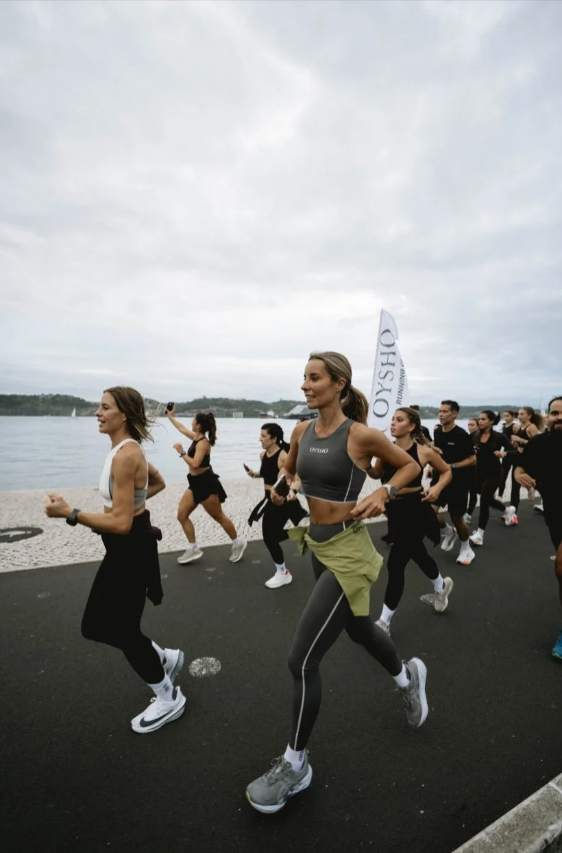 Grupo de personas corriendo al aire libre cerca de un cuerpo de agua en un evento de running