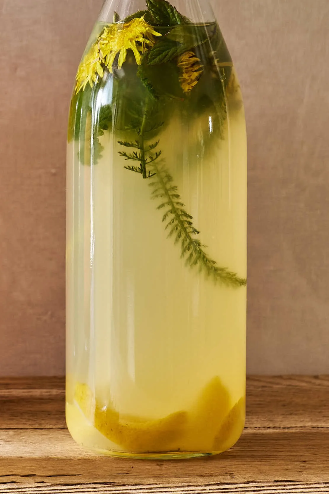 Vorratsglas mit Zitronenscheiben, Minz- und anderen Kräutern sowie Wasser