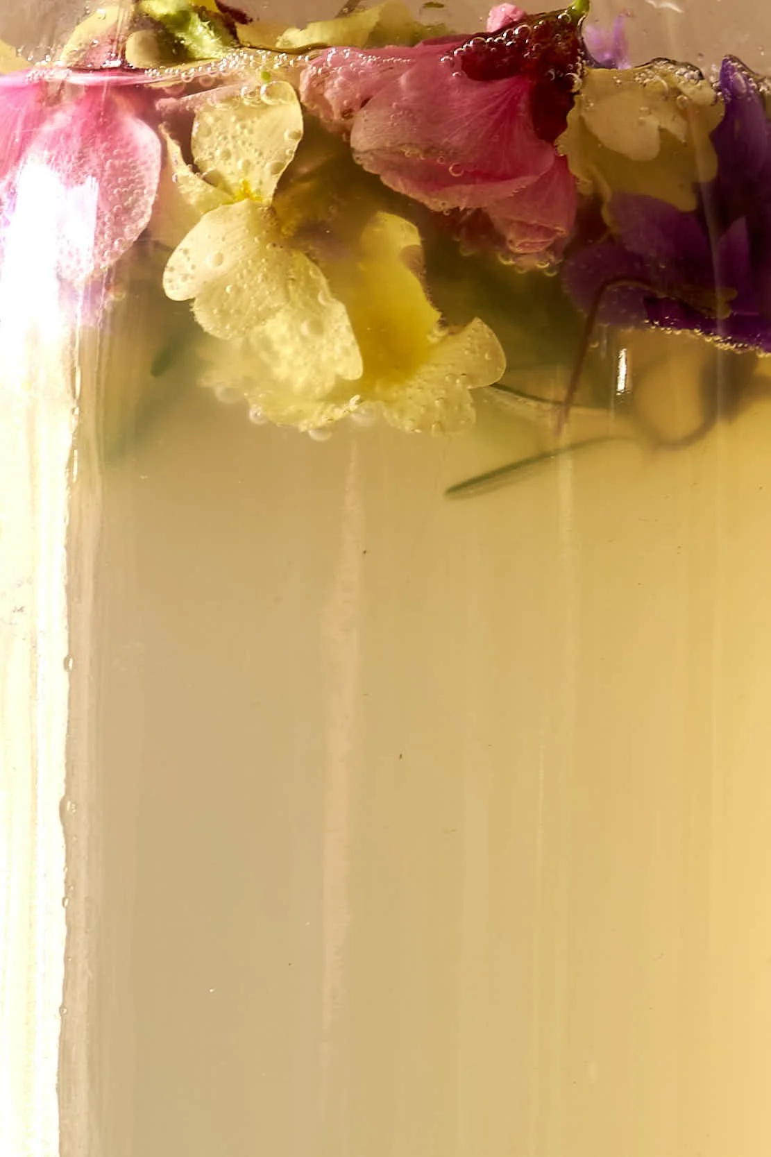 Bunte Blütenblätter schwimmen in Wasseroberfläche.