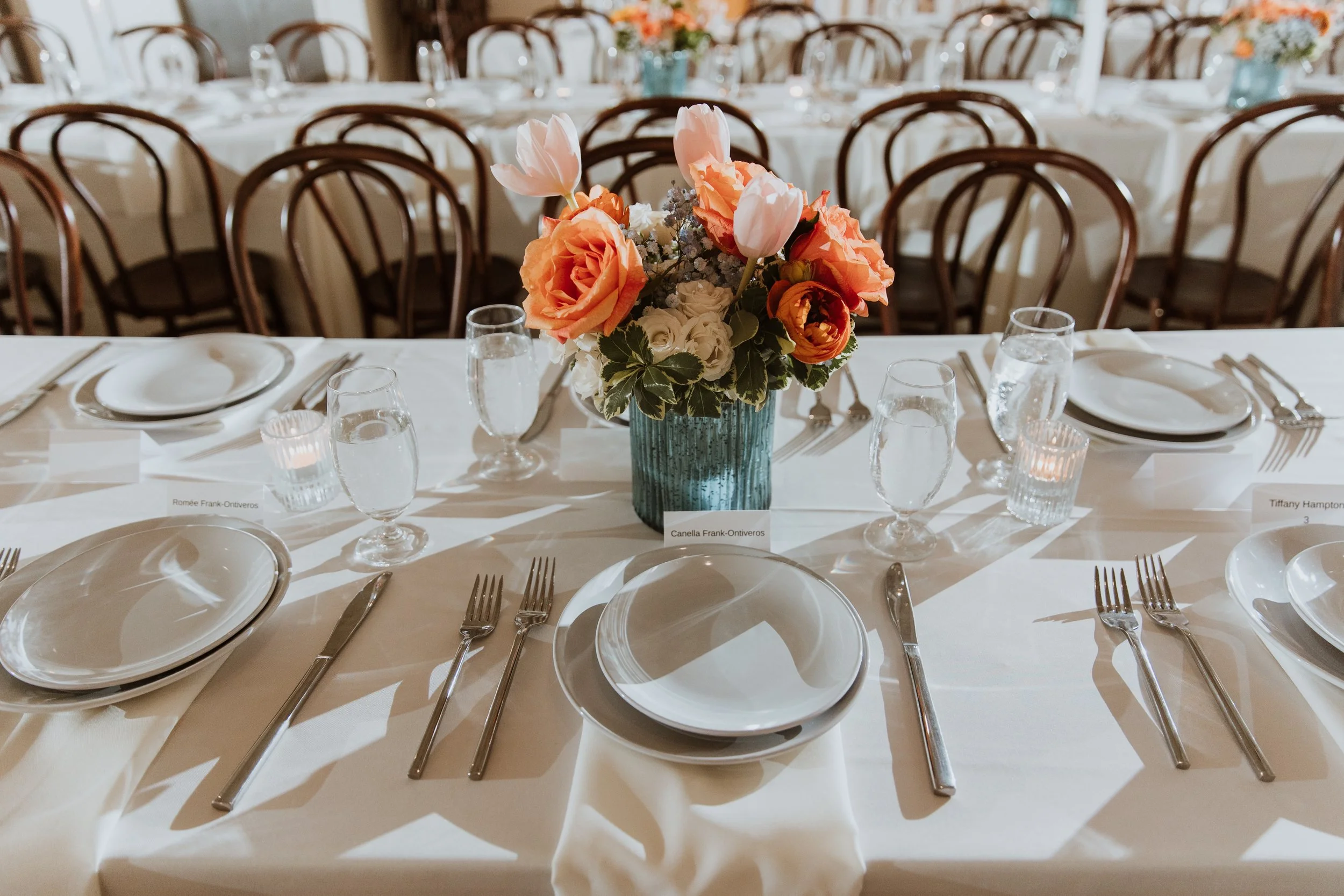 Detailed formal place cards placed at individual table settings with custom catering meal indicators.