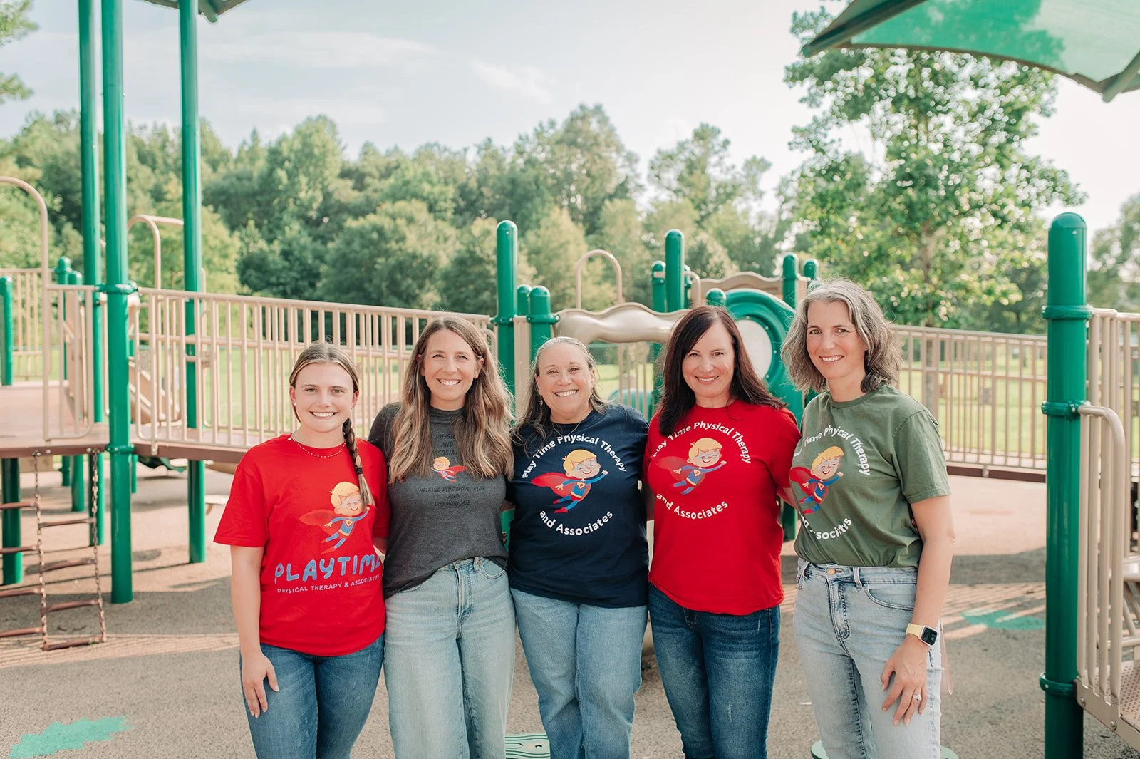 Group photo of staff with playground in the background.