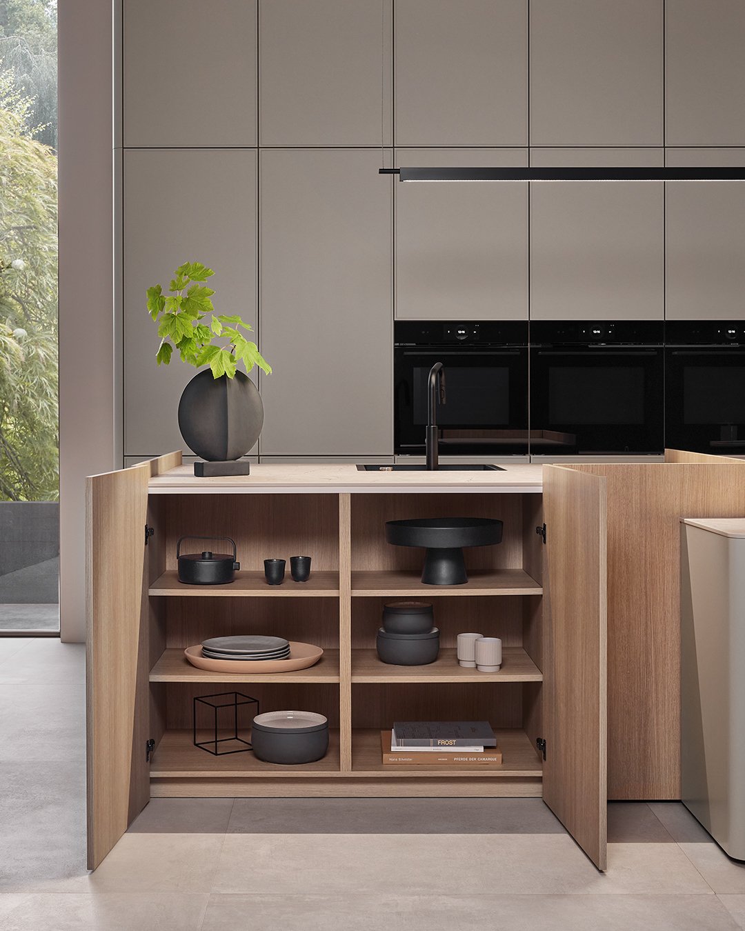 Modern kitchen with beige cabinets, black appliances, and an open wooden shelving unit with black and neutral dishes and decorative items.