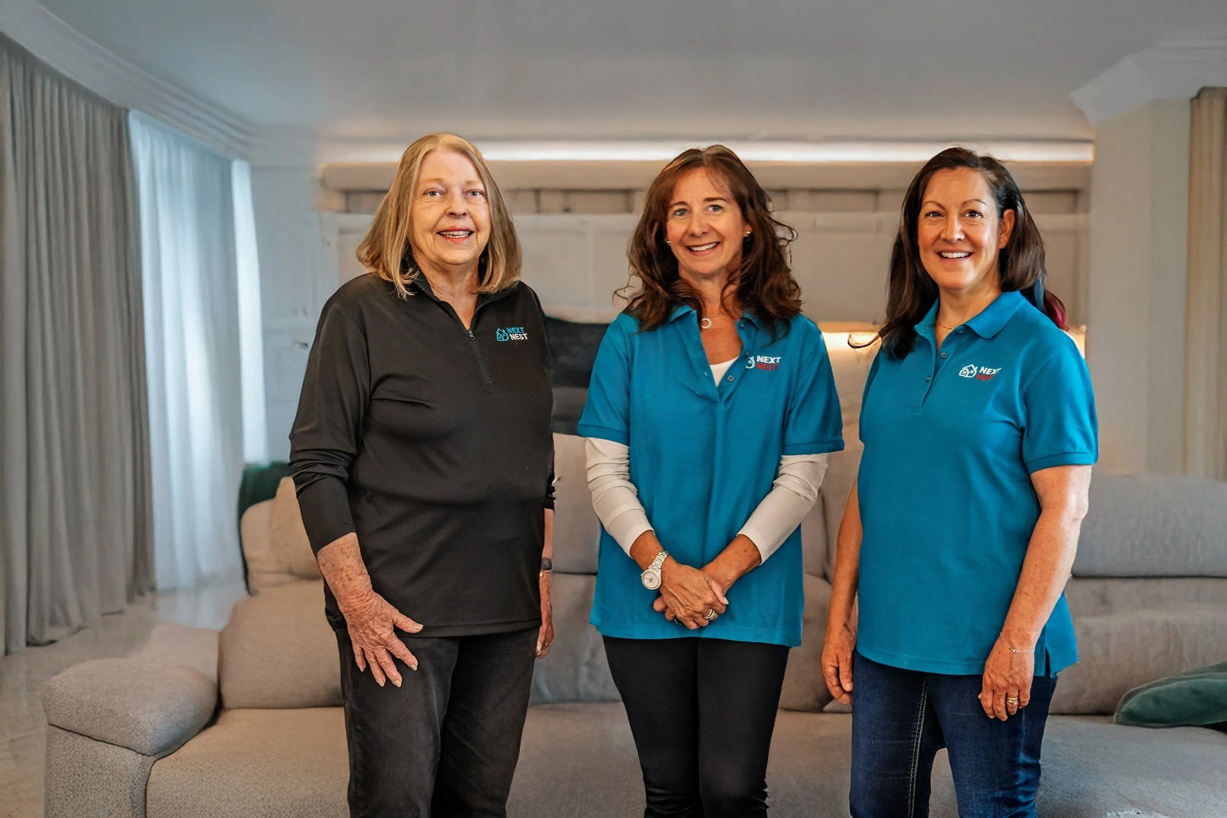 Norma Wall, Marian Porter and Sharon Sinnes standing in living area of Next Nest moving project.