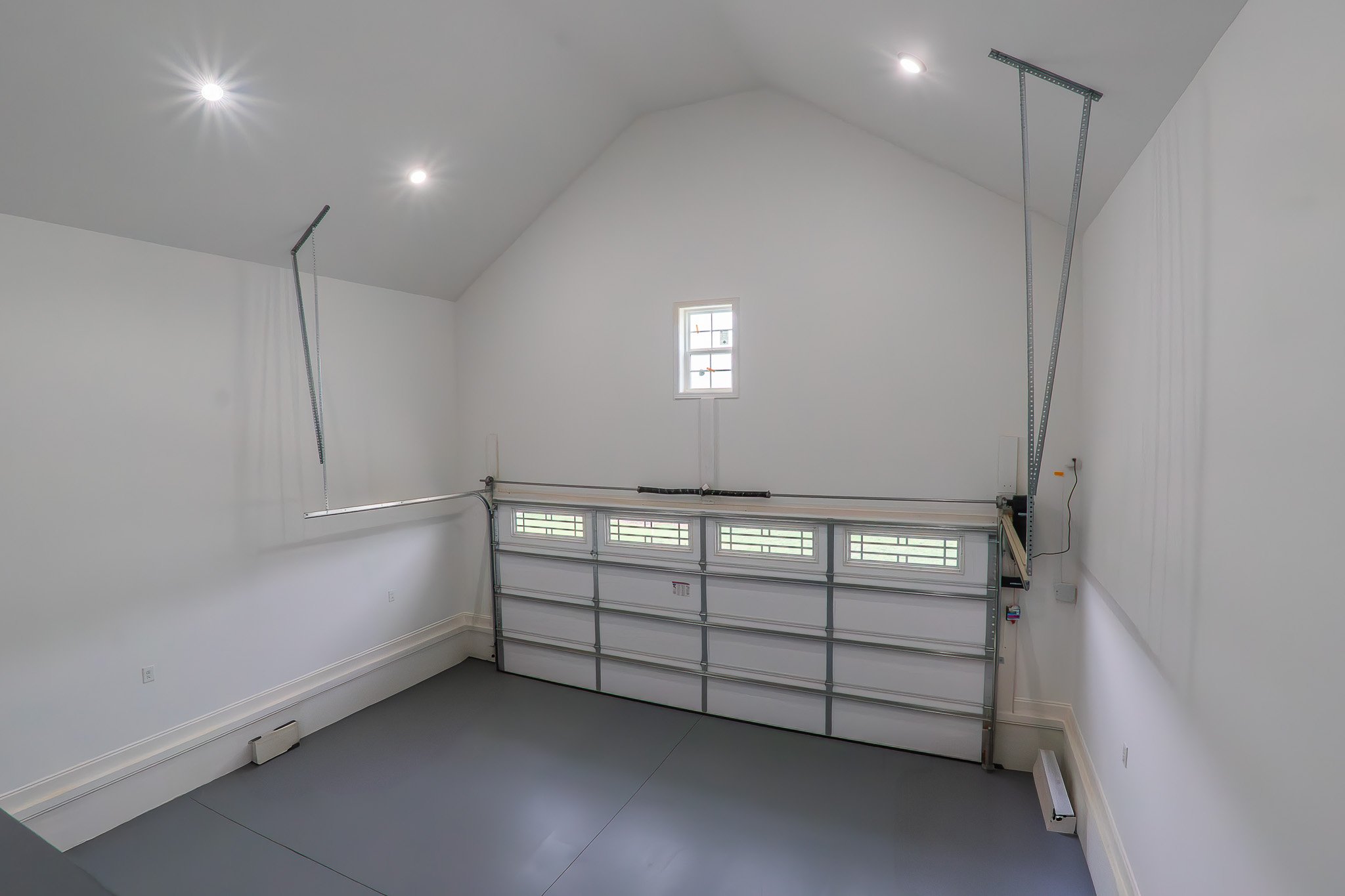 Empty garage interior with white walls and closed garage door