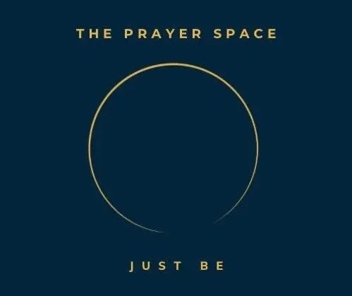A dark blue background with gold text reading 'The Prayer Space' at the top, a gold circle in the center, and gold text at the bottom reading 'Just Be'.