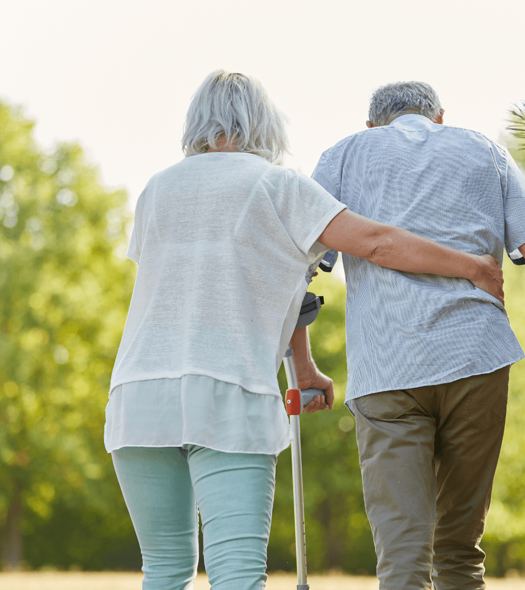 Caregiver assisting an older adult with physical therapy and rehabilitation exercises in a skilled nursing setting