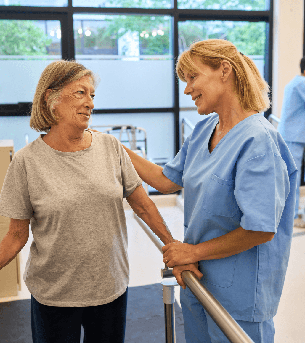 Caregiver assisting an older adult with rehabilitation exercises in a skilled nursing setting