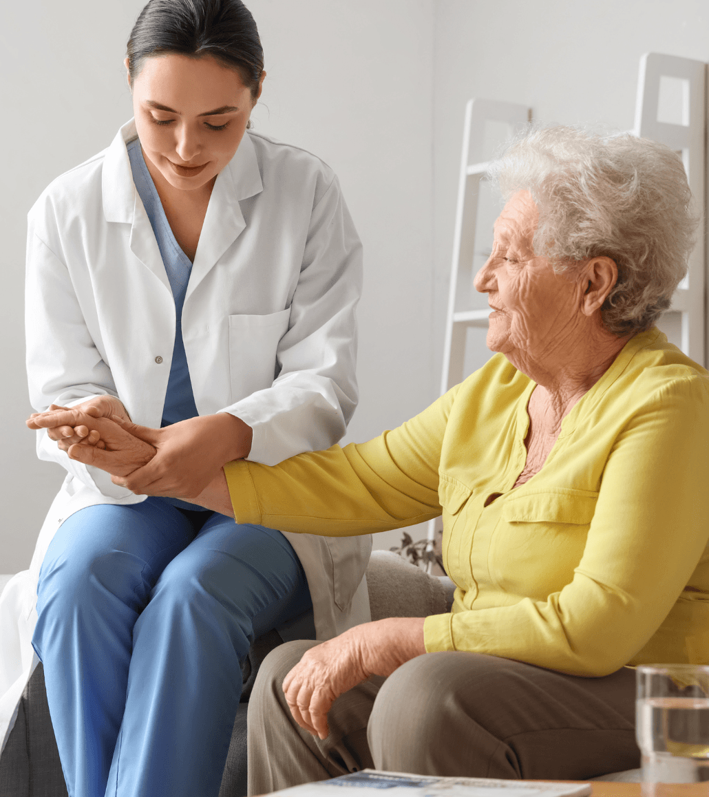 In-home caregiver assisting an elderly woman with mobility and daily care in a home setting