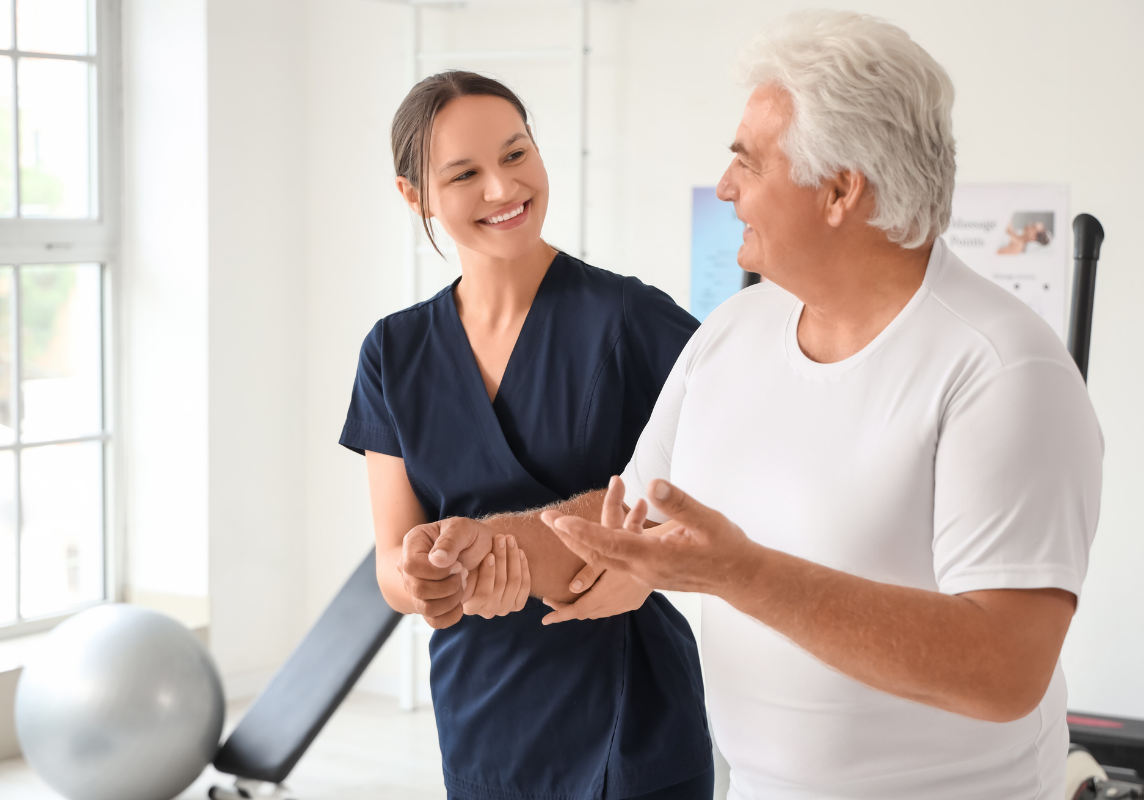 Caregiver assisting an older adult with mobility and rehabilitation exercises in a skilled nursing setting