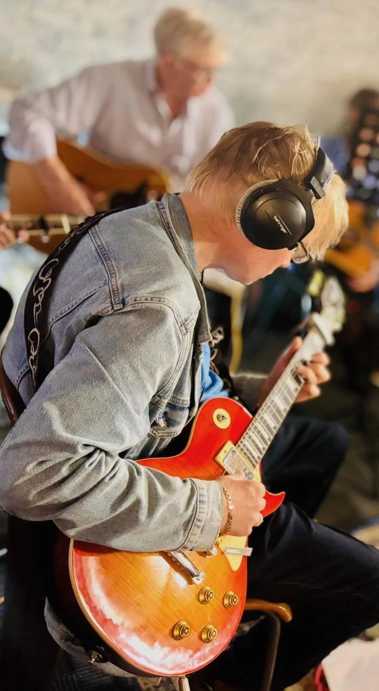 A man playing a guitar during a SoCo Music session
