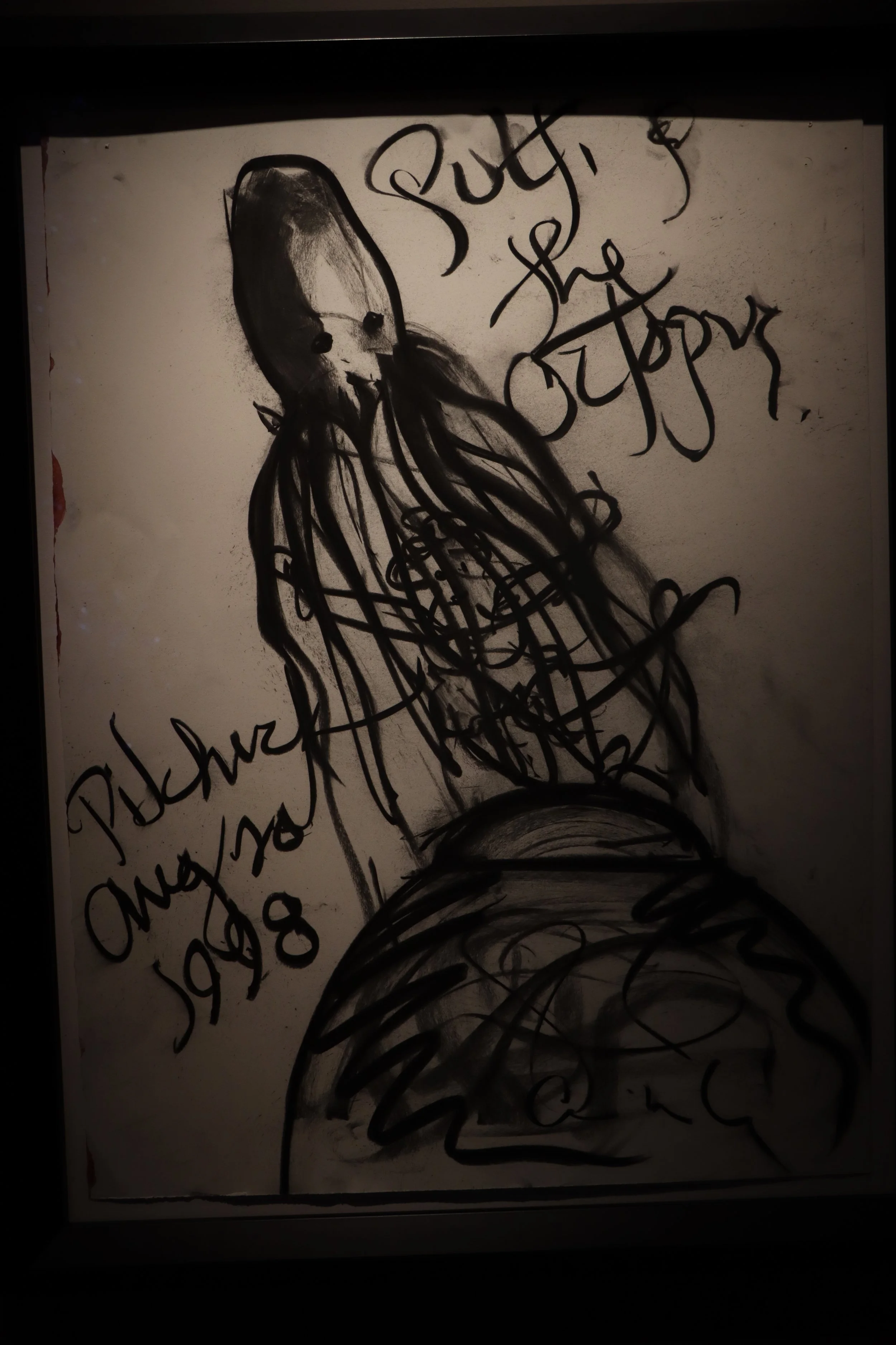 A black and white drawing of a woman with long hair, with handwritten text that says 'Support the Octopus,' 'Pictured August 2008.'