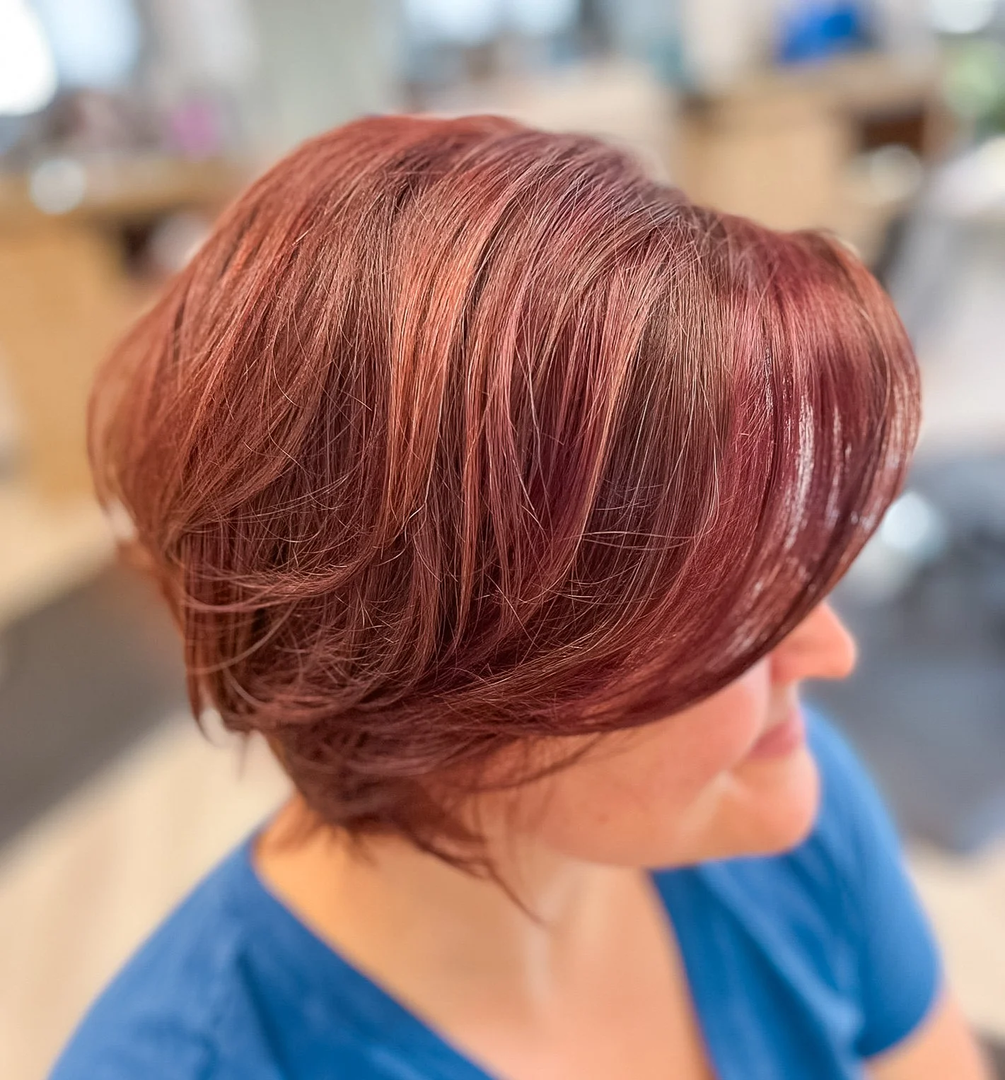 Woman with short, layered, reddish-brown hair styled in a smooth bob.