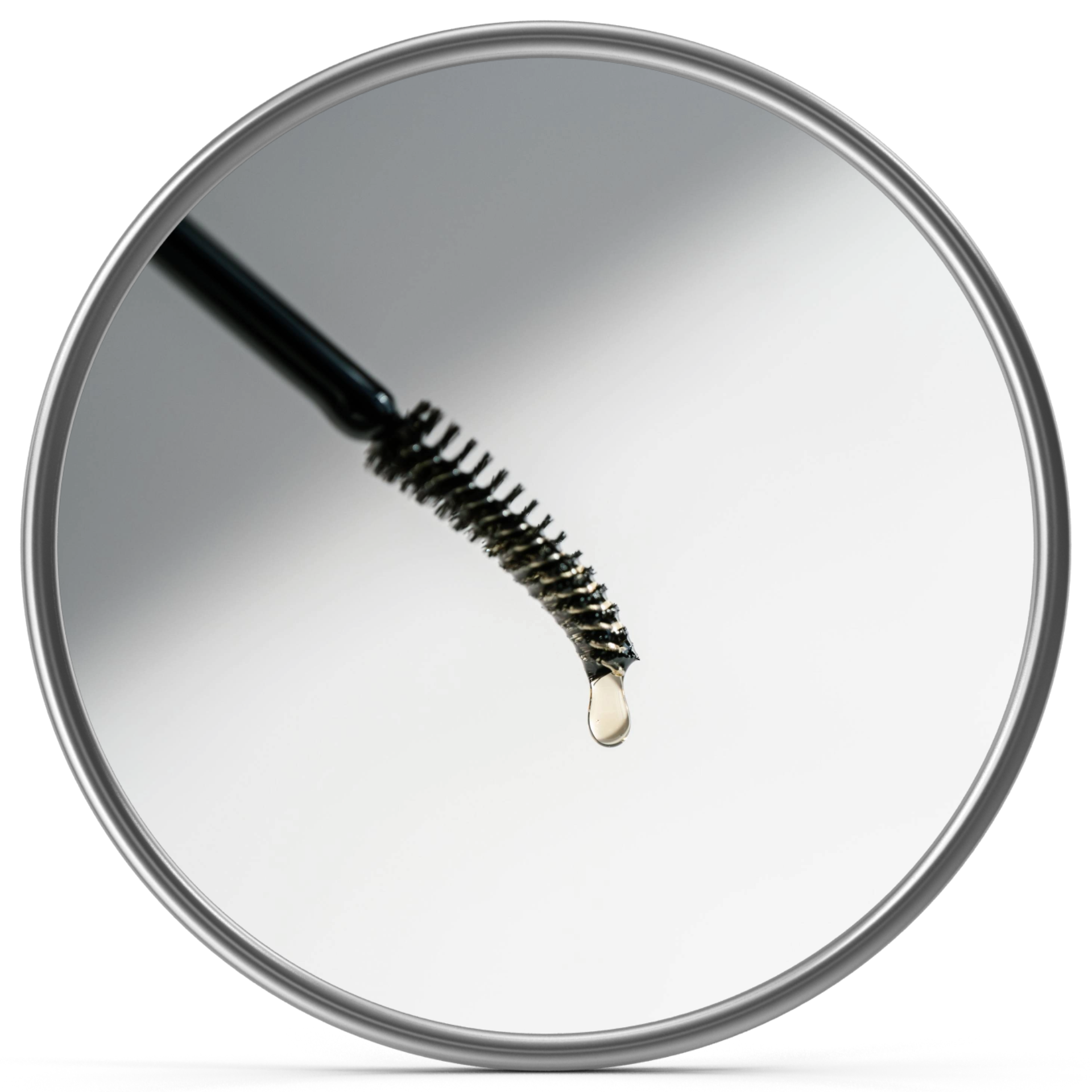 Close-up of a mascara mascara wand with a drop of liquid on its bristles. The wand is held above a shiny circular surface, likely a mirror or compact.