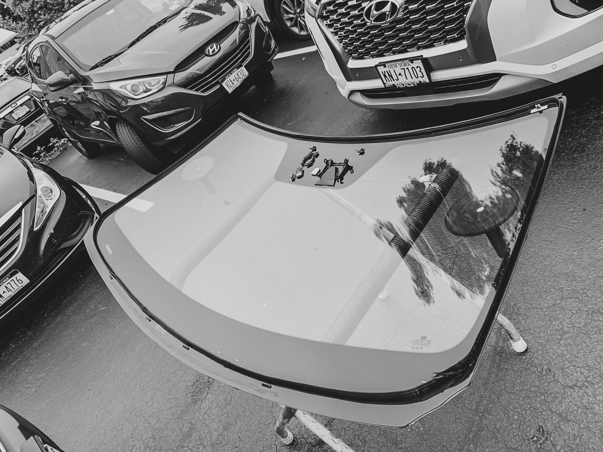 Replacement windshield resting on a stand in the shop
