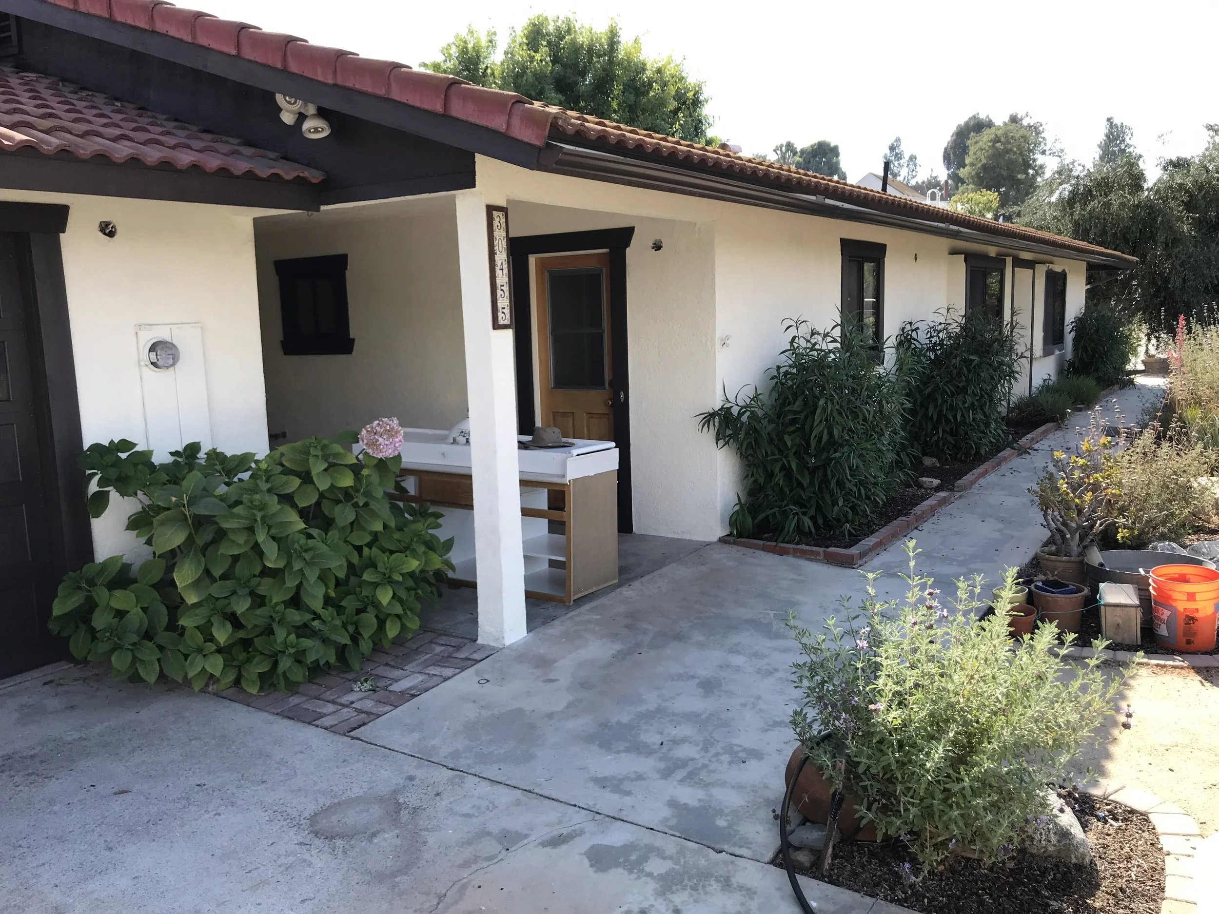 Spanish style home with white stucco and dark trim painted by Garrett Dalton Inc