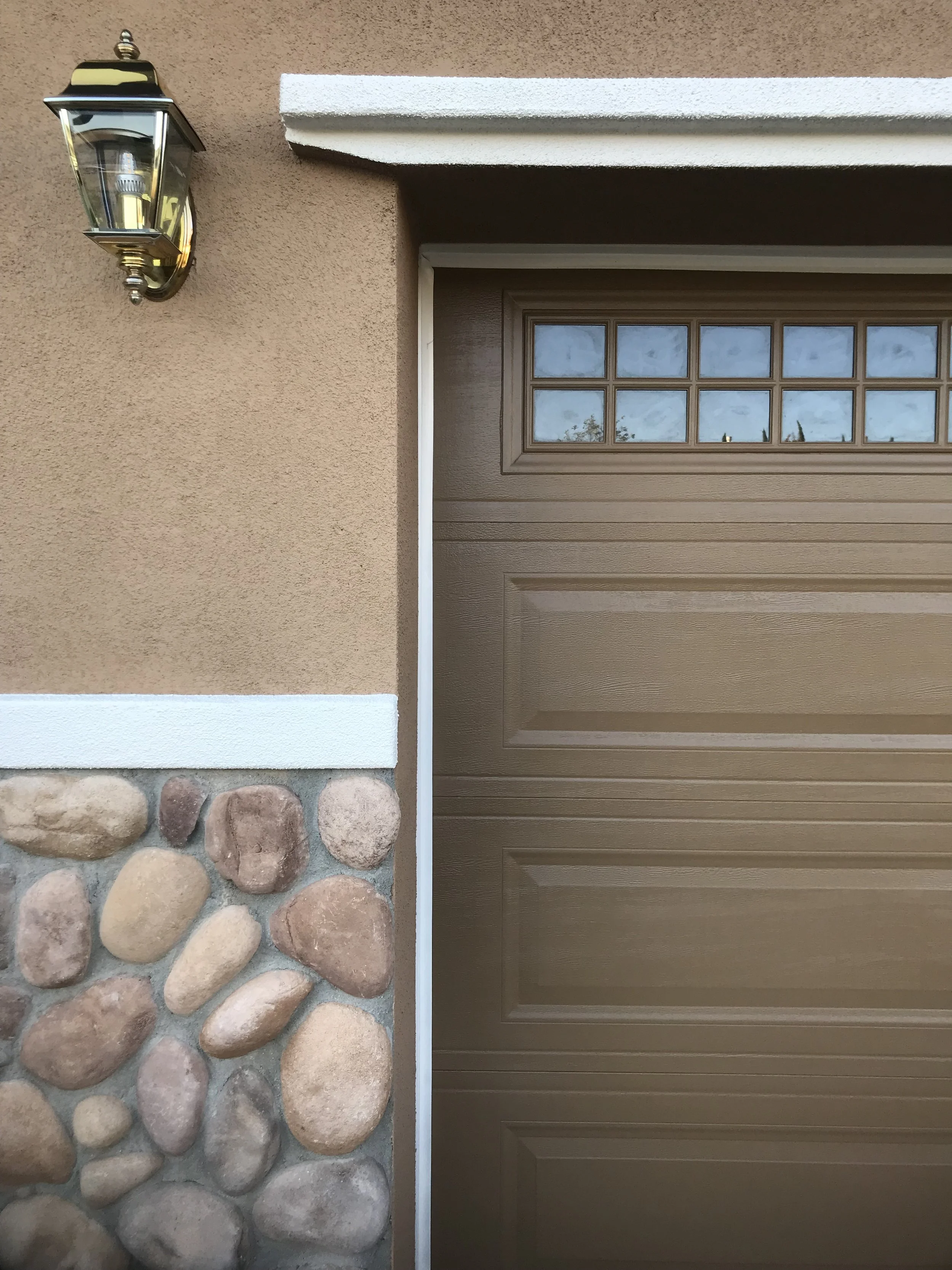 Brown exterior color scheme garage door that matches stonework, painted by Garrett Dalton Inc
