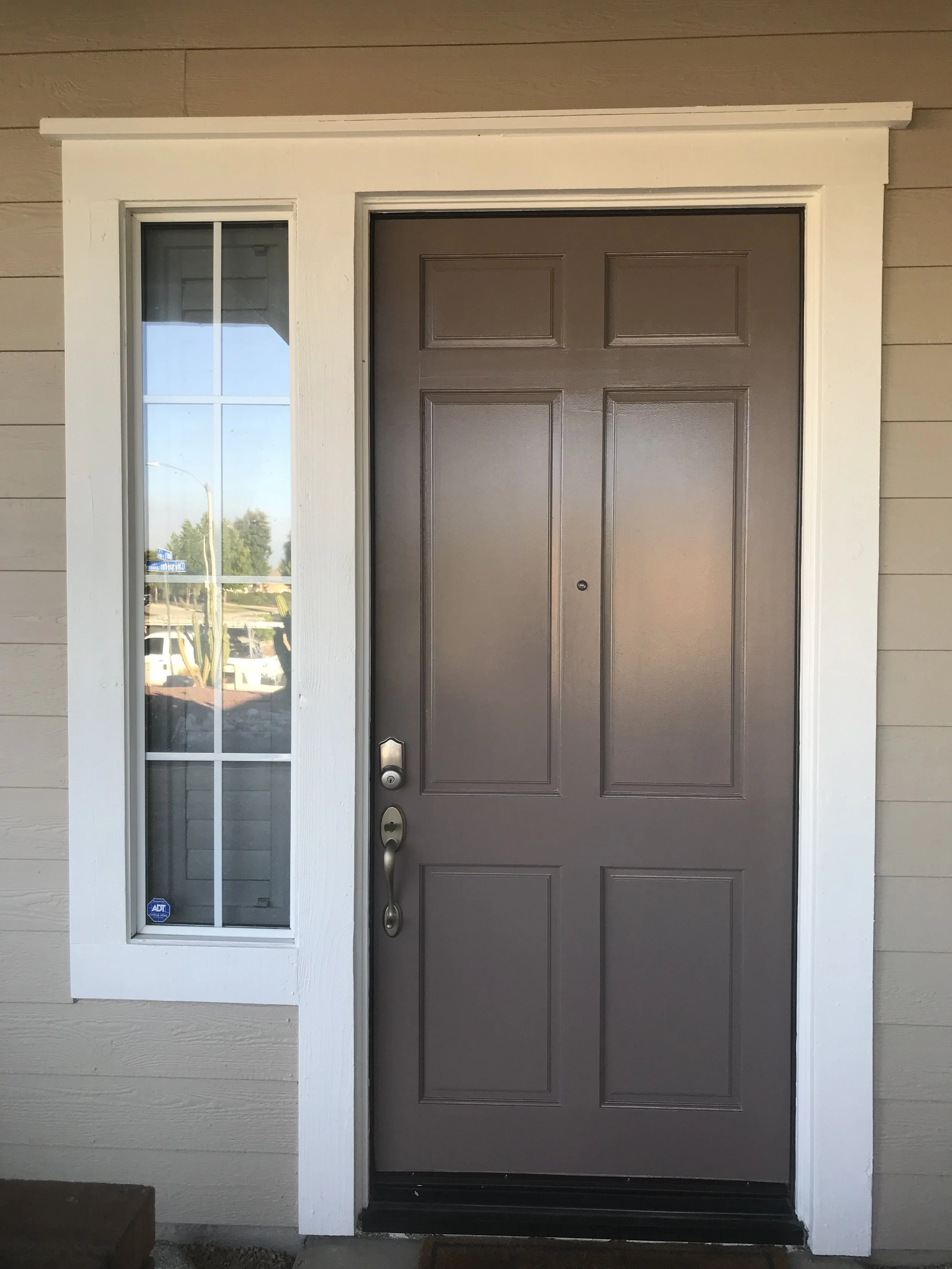 Brown front door neutral warm beige exterior color scheme with white trim painted by Garrett Dalton Inc