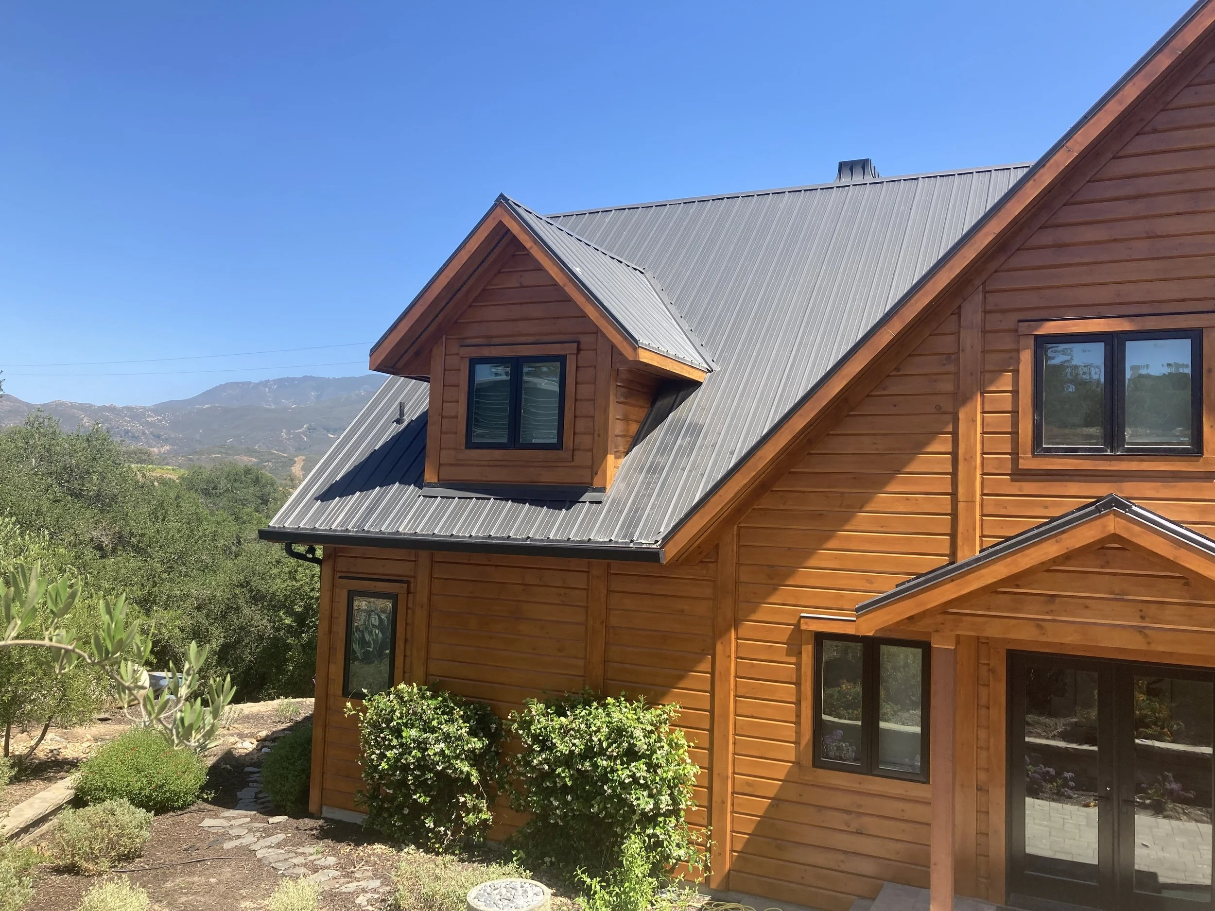Red wood stained log cabin in the hills painted by Garrett Dalton Inc