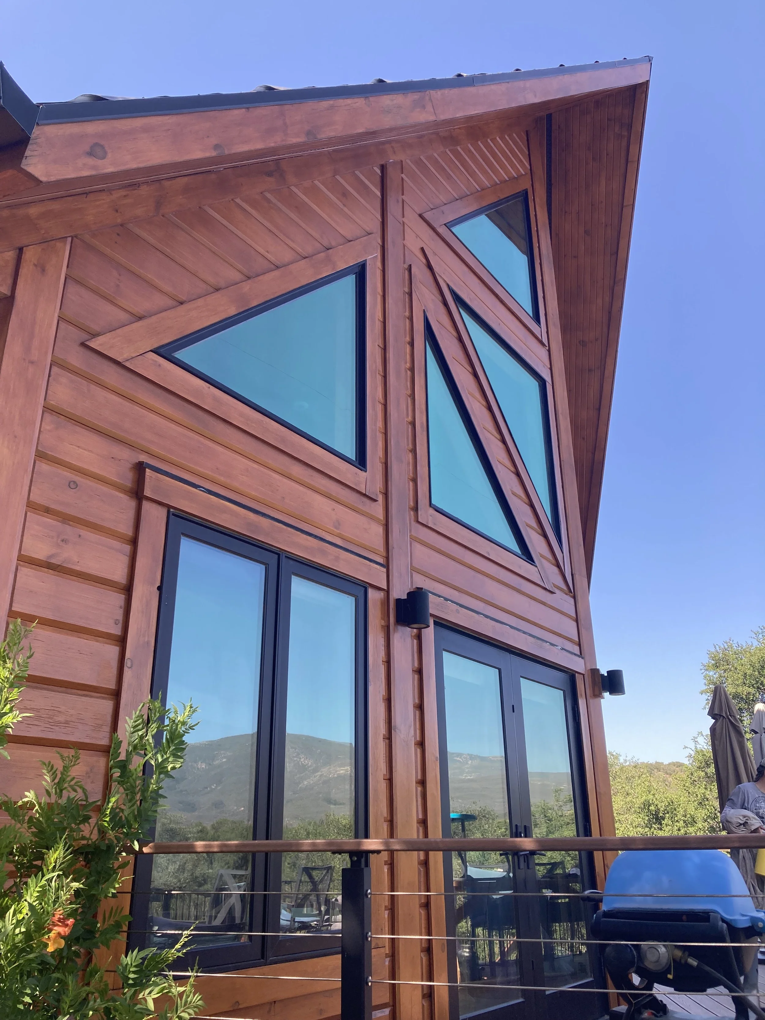 Log cabin with stained wood painted by Garrett Dalton Inc