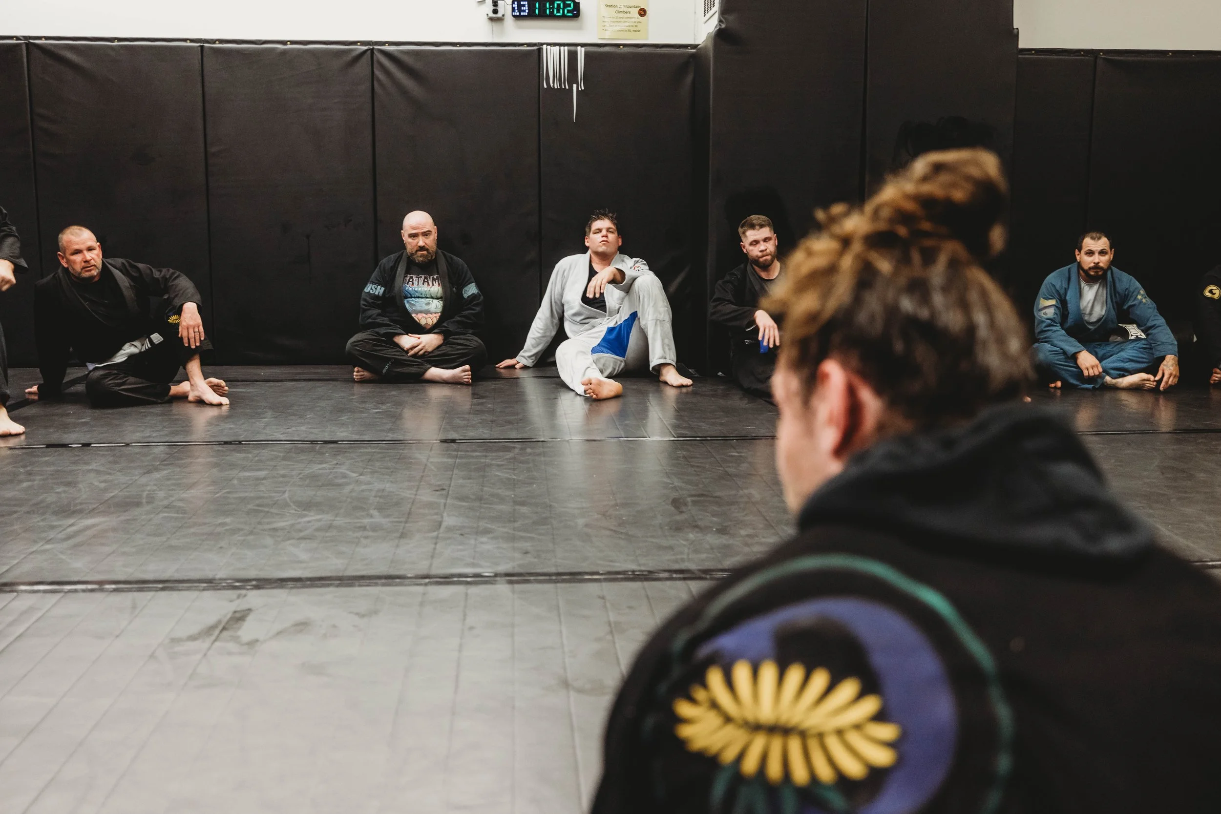 Black belt coach instructing a Brazilian Jiu Jitsu student in West Haven, CT