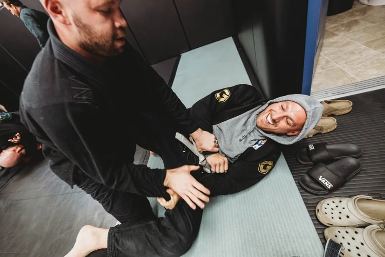 Coach teaching an adult Brazilian Jiu Jitsu technique in West Haven, CT
