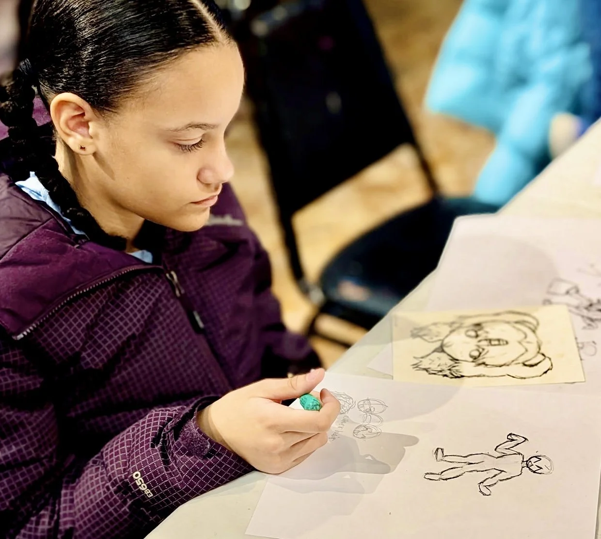 Student sketching an anime-style character during an after-school art class at the Heart of Art