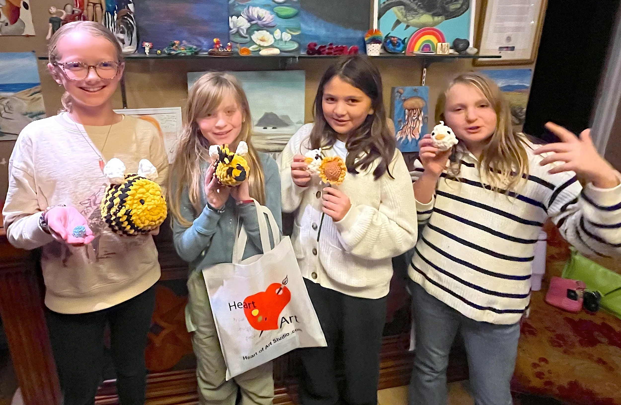 Kids holding handmade crochet projects during a crochet class at Heart of Art Studio in Hamilton, New Jersey