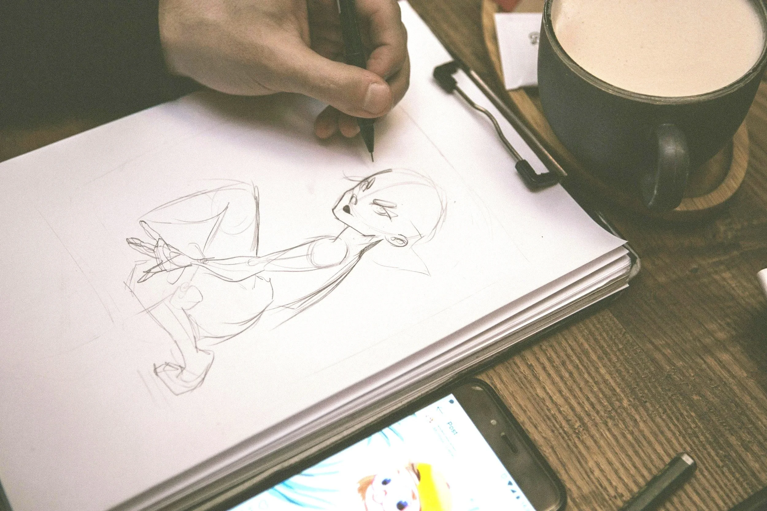 Student sketching an anime character during an anime drawing and design class.