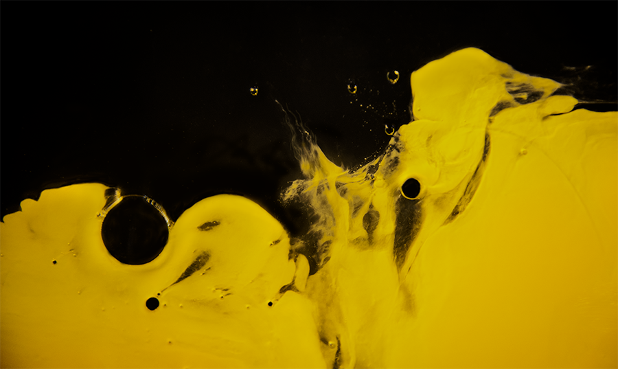 Minimalist photograph of a dynamic pure yellow element on a black background – Part 1 of the series 'In Yellow: Purity, Bloom, and Taste' photo by Nahid Naderi.