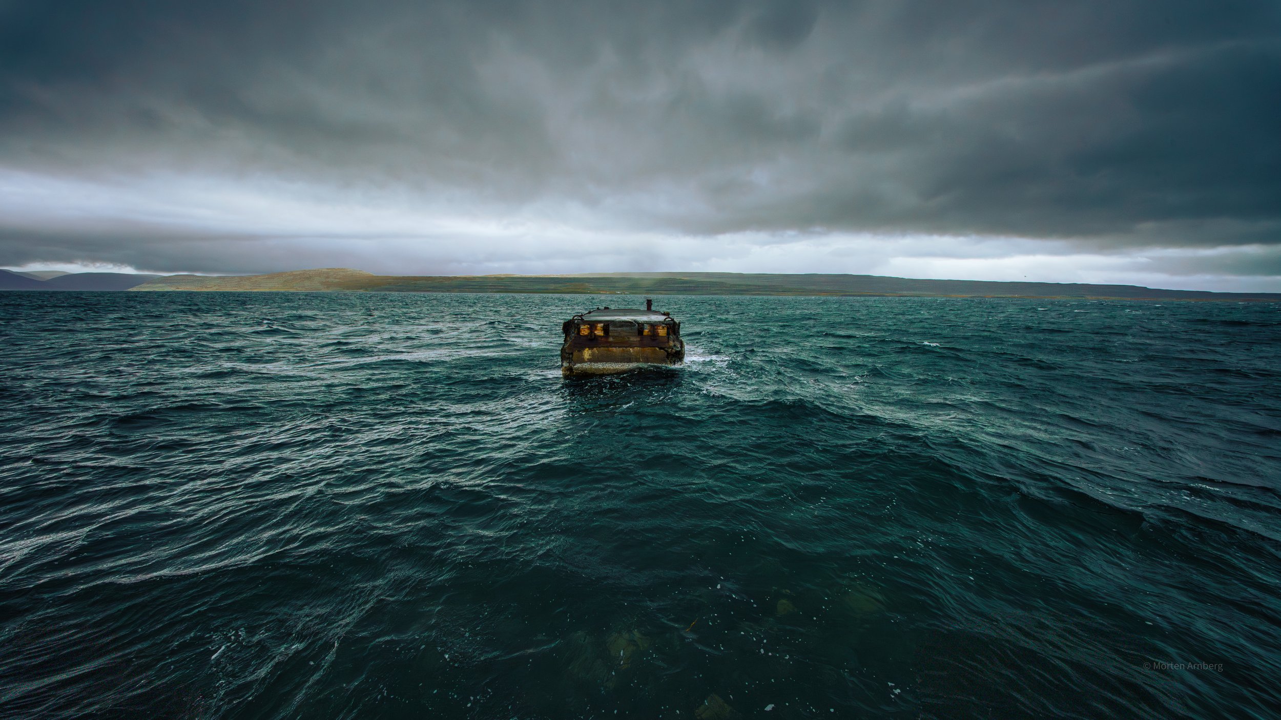 A decayed Iceland West Fjord bridge - long since having lost its connection to the shore. Now part of the landscape scenery, somehow adding to the epic landscape.