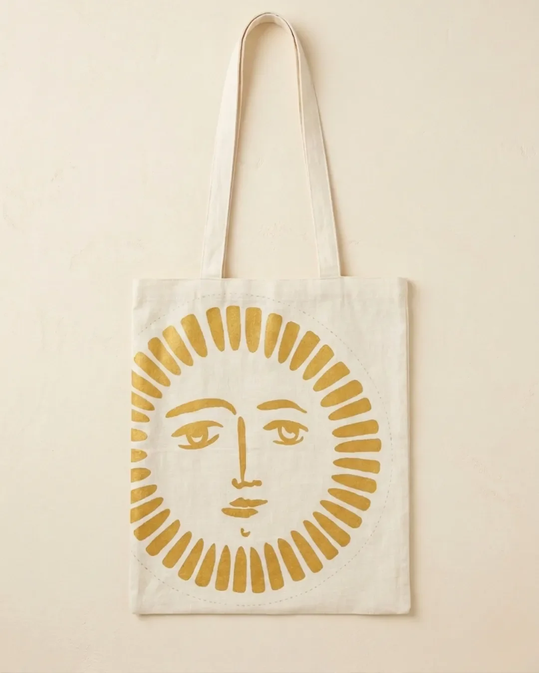 Natural cream canvas Sun Bag featuring a gold sun face graphic, Handmade by Soli in Cape Town for sustainable merchandise or corporate gifts.