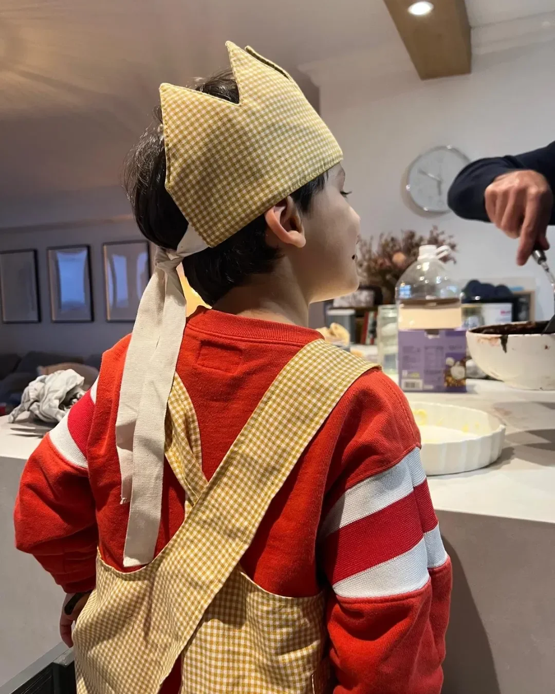 A matching set featuring an ochre gingham kids' apron and crown representing sustainable kids crown for custom corporate gifts by Soli, made in cape town.