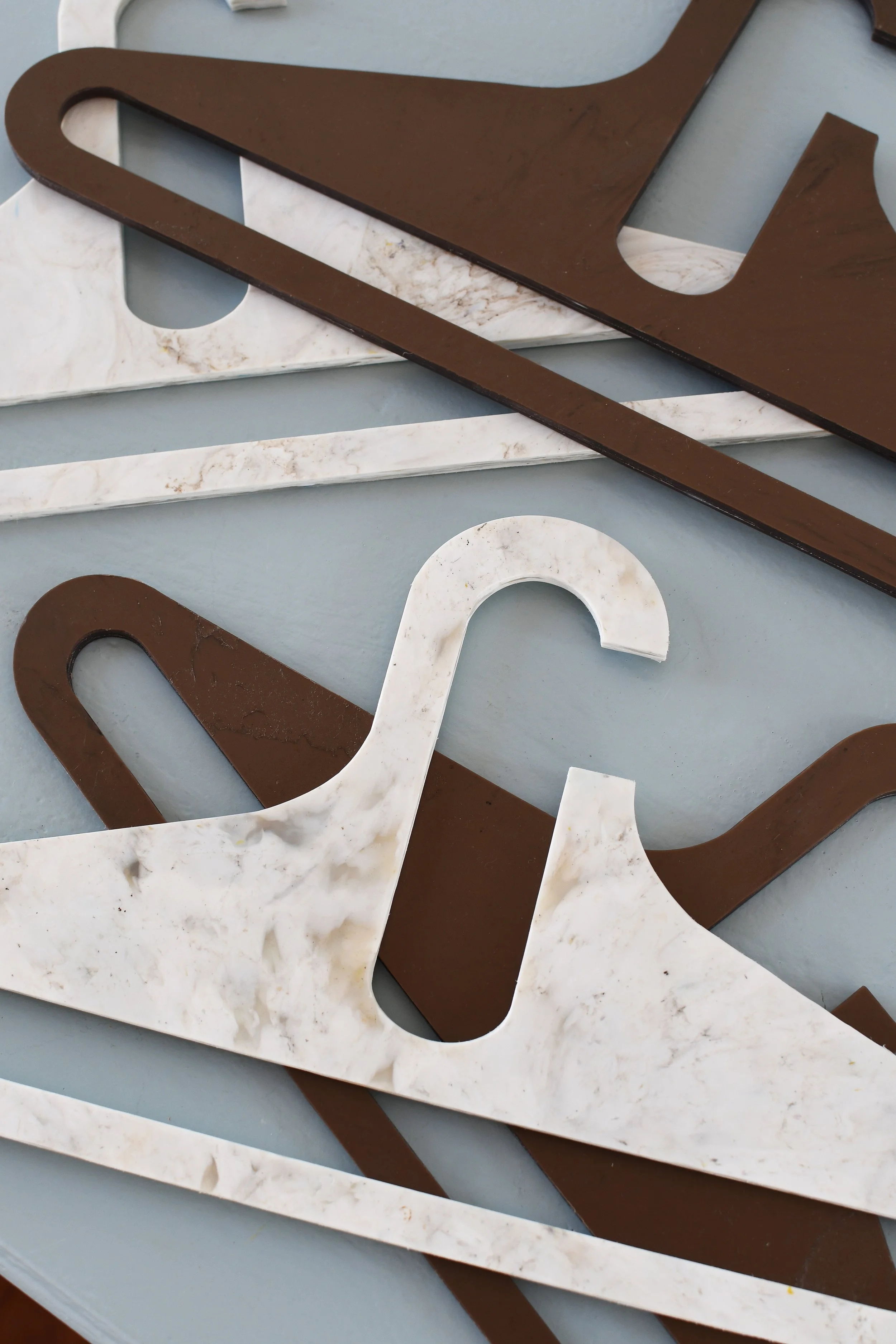 Stack of brown and white marble-patterned hangers on a surface