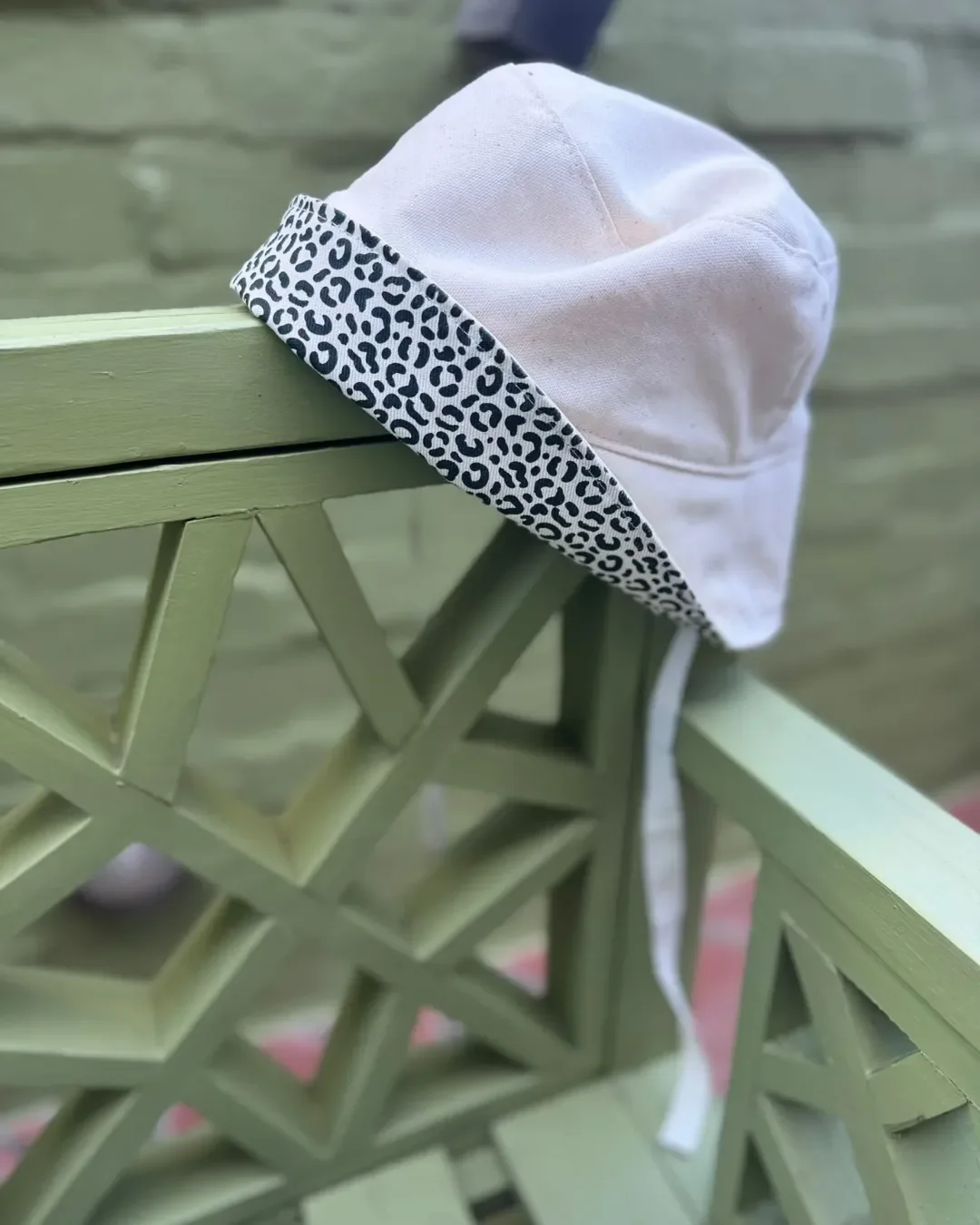 Model wearing a Soli custom cream bucket hat with branded logo ribbons and a matching canvas crossbody bag, handmade in Cape Town for sustainable corporate merchandise.