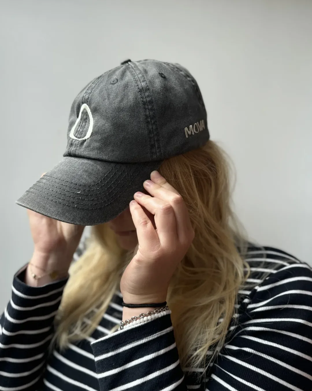 Side view of a charcoal grey vintage washed cotton cap featuring custom white embroidery on the front and side, highlighting Soli's sustainable branding options for corporate gifts in South Africa.