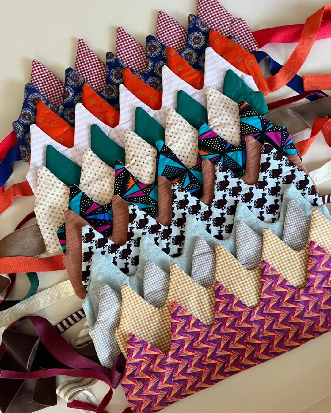 A row of handcrafted kids' crowns made from authentic patterned Shweshwe fabric and natural canvas, displayed as premium sustainable corporate gifts and merchandise from Soli, made in Cape Town.