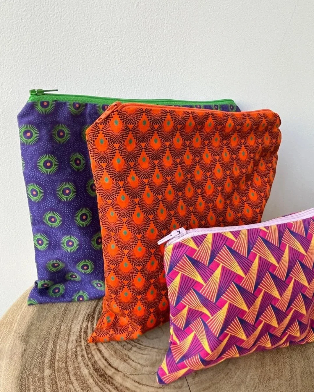 hree vibrant handmade African pouches in purple, orange, and pink patterned shweshwe fabric, sustainable corporate merchandise crafted in Cape Town by Soli.