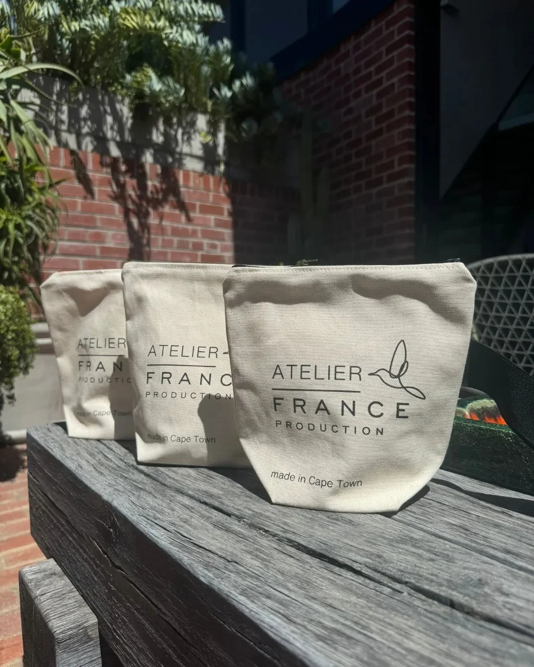 Three handmade Berlin cosmetic pouches in natural canvas with custom printed logos and colorful handles, sustainable corporate merchandise made in Cape Town by Soli