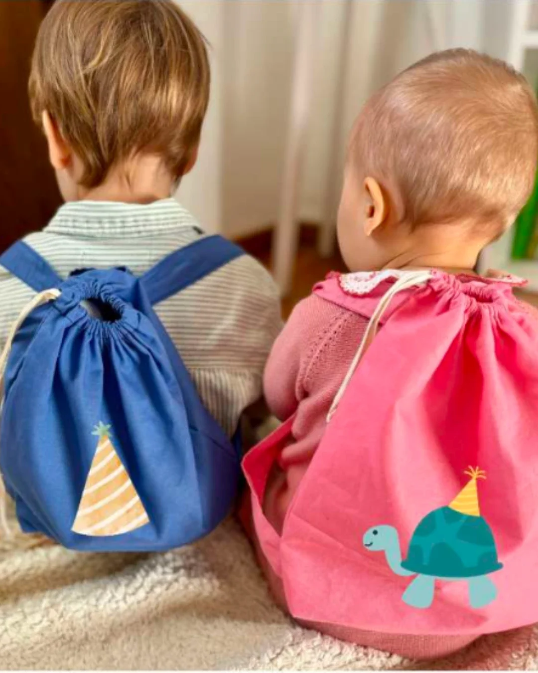 A collage featuring toddlers wearing Soli's handmade mini backpacks in vibrant pink and blue, showcasing custom printed logos like a tractor, turtle, and party hat. Made in Cape Town for corporate gifts and merchandise.