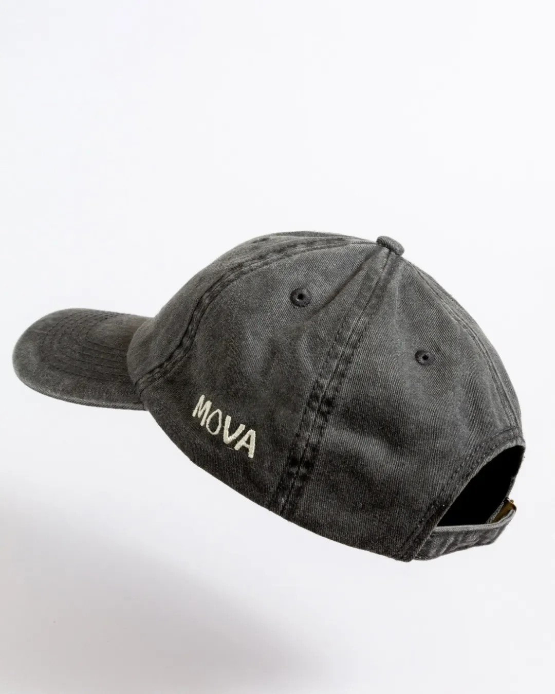Side view of a washed black cotton canopy cap featuring off-white side embroidery reading "MOVA", custom branded by Soli in Cape Town.